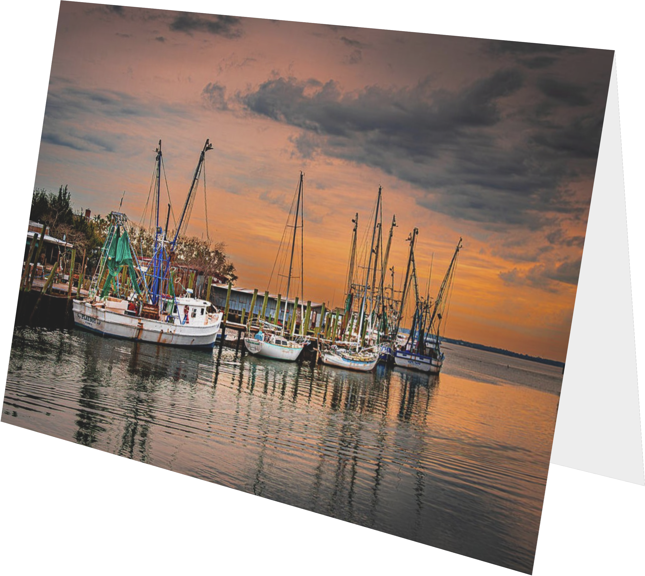 Sailboats docked at a marina during sunset with dark clouds overhead and water reflecting the colors of the sky.