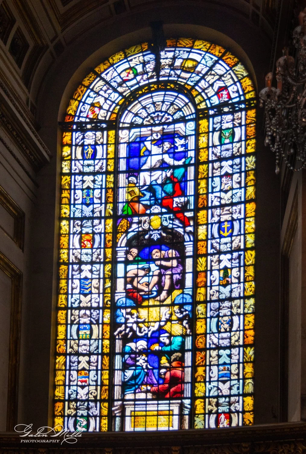 Stained glass window with colorful religious scenes and patterns