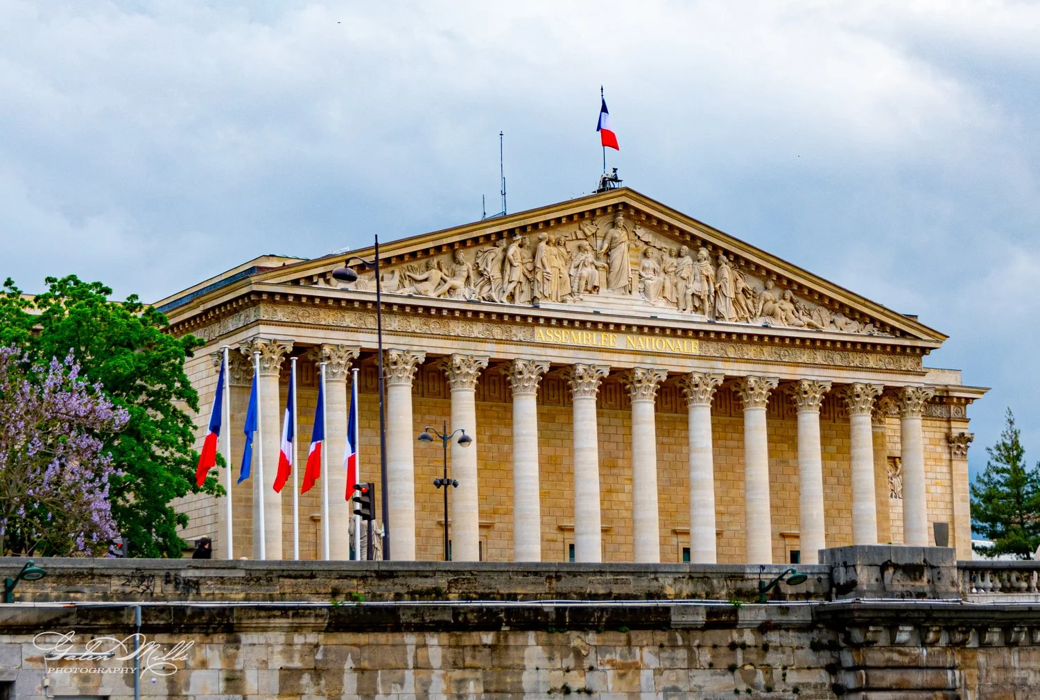 French National Assembly building with columns and French flags