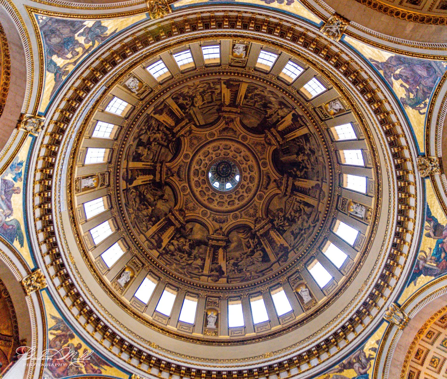 Ornate interior dome ceiling with intricate designs and windows, architectural detail.