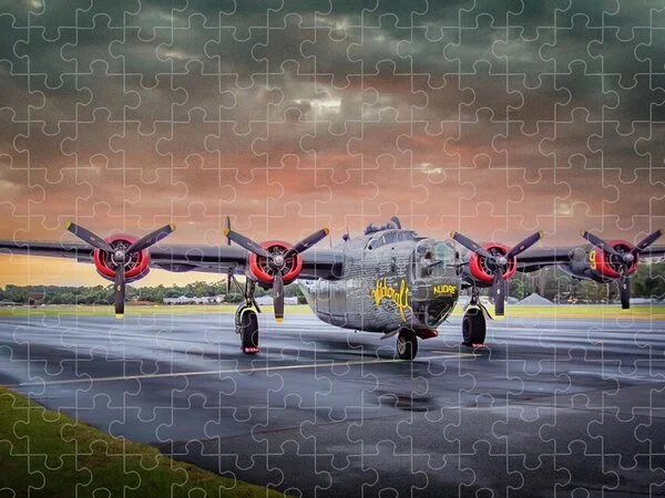 A military aircraft with four propellers and black, red, and yellow accents parked on a runway during sunset.