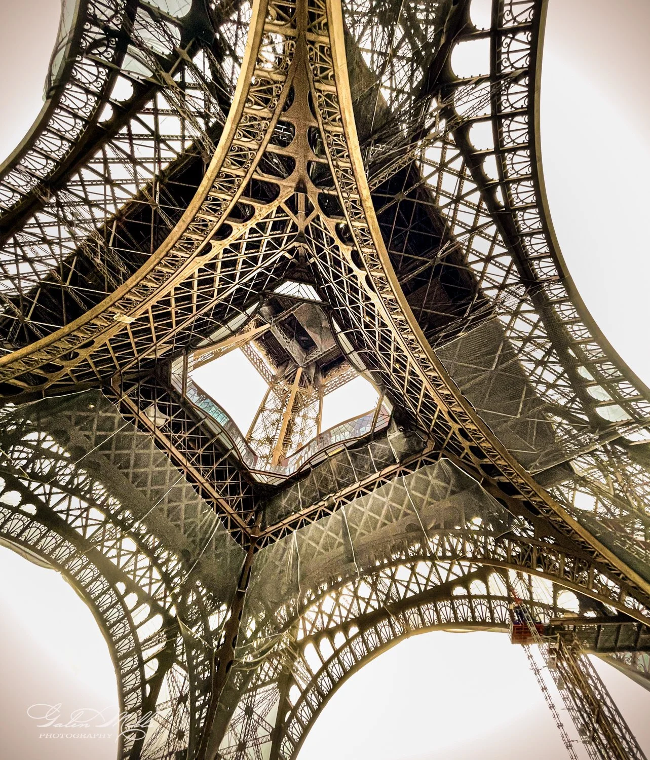 View from underneath the Eiffel Tower showing intricate iron latticework.