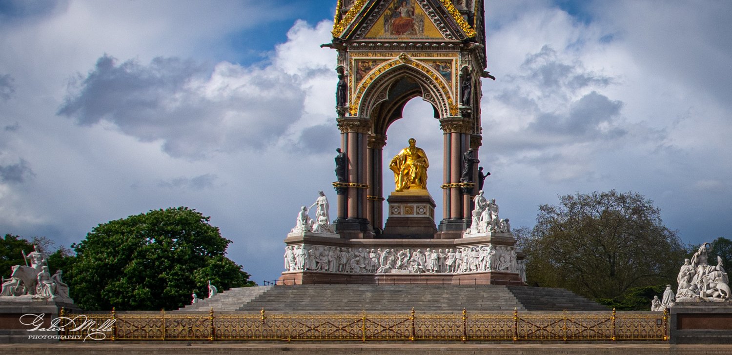 Golden statue under an ornate canopy, surrounded by sculptures and decorative architecture.