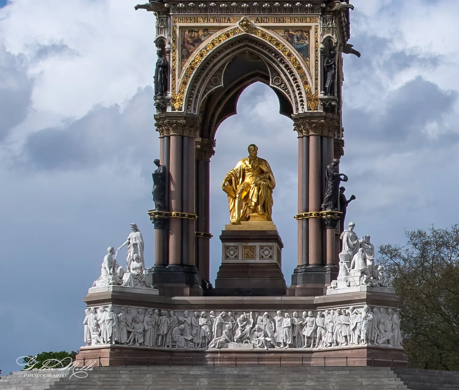 The Albert Memorial in London, featuring a gilded statue of Prince Albert seated under an ornate canopy, surrounded by sculptural groups.