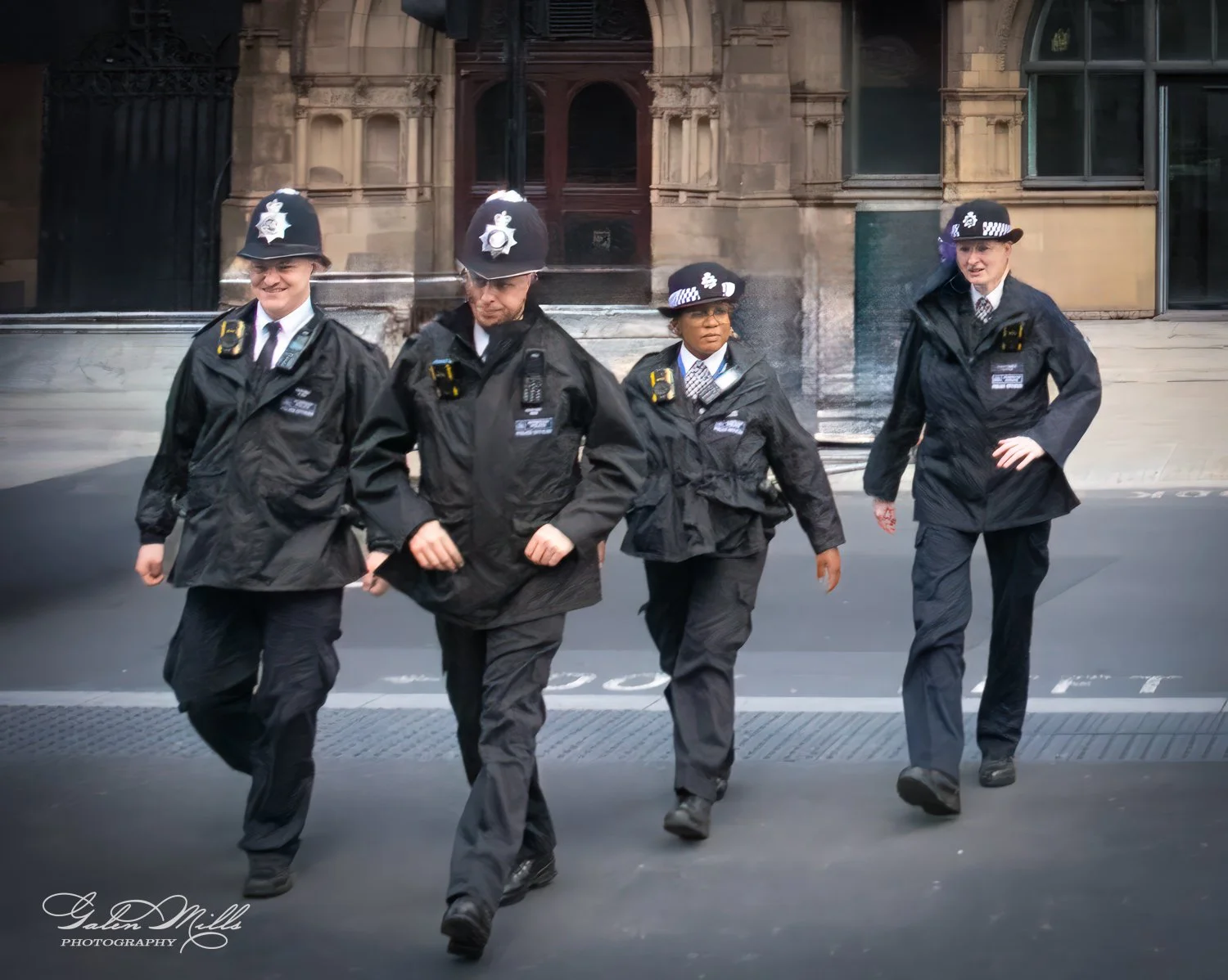 Four police officers in uniform walking outdoors.