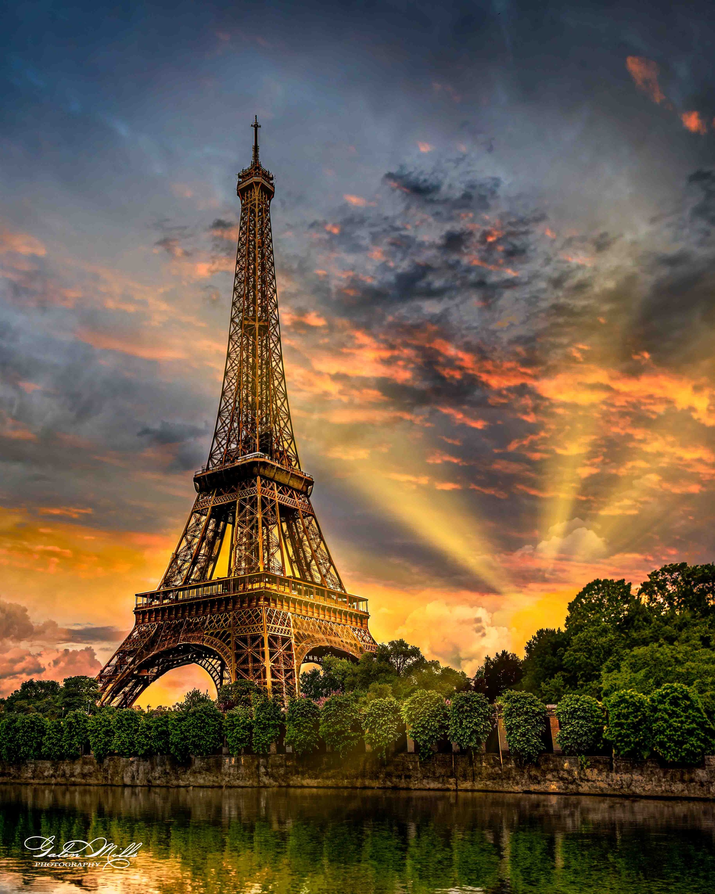Eiffel Tower at sunset with colorful sky and rays of sunlight