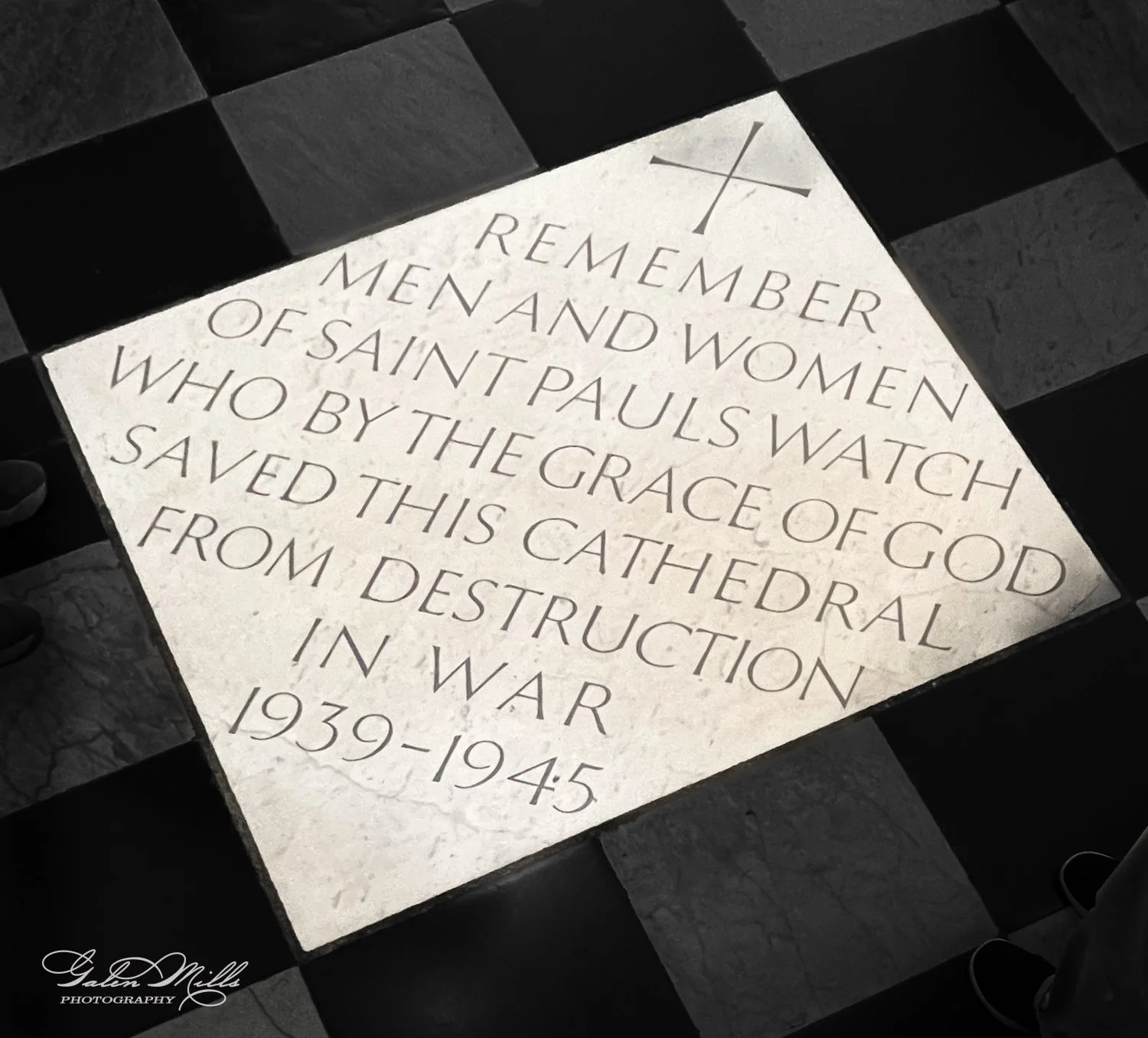 Marble plaque with engraved text commemorating men and women of Saint Paul's Watch who saved the cathedral during 1939-1945. Plaque is on a checkered floor.