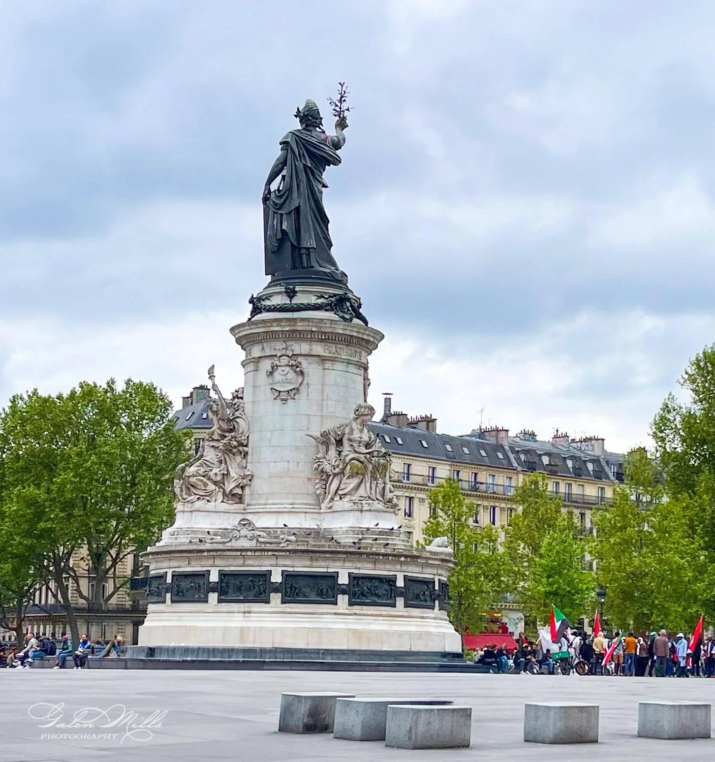 Statue in Place de la République in Paris, with trees and buildings in the background.