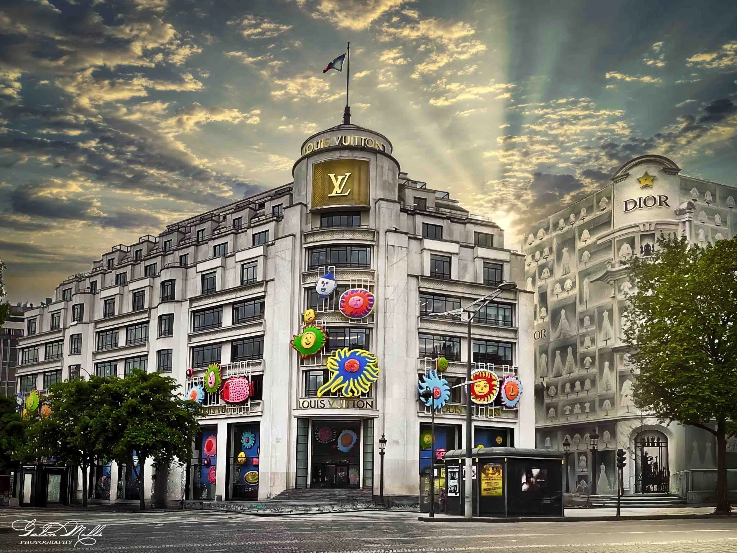 Exterior of Louis Vuitton building with colorful designs and adjacent Dior facade under cloudy sky.