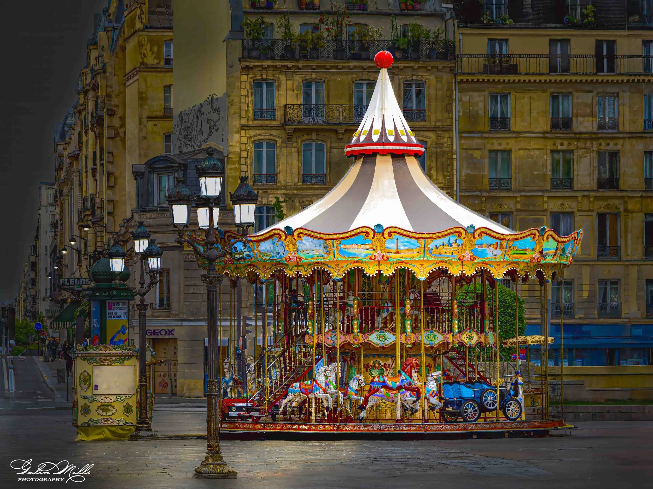 A colorful vintage carousel in a European city setting, surrounded by historic buildings and streetlights.