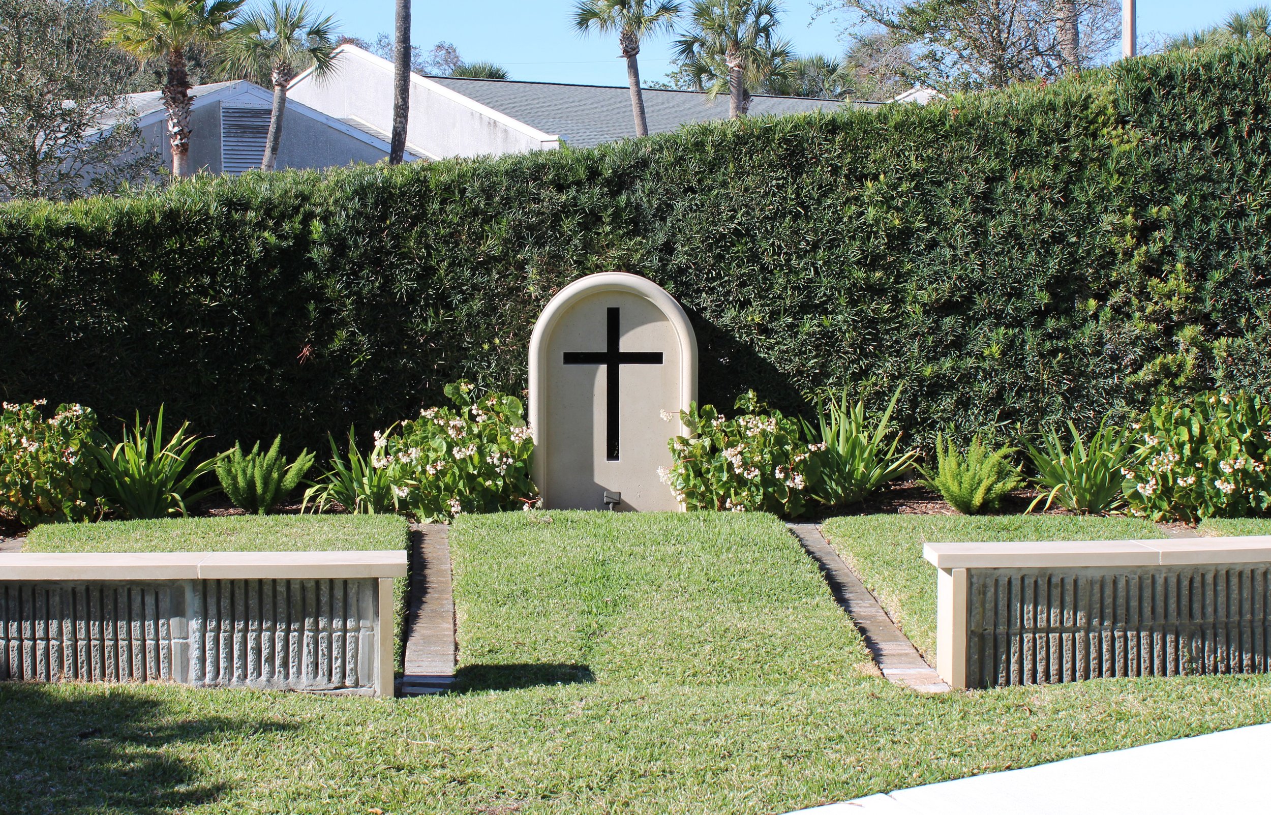 Cross monument and seat wall cap in garden at St. Paul's by the Sea Episcopal Church in Jacksonville Beach, FL.