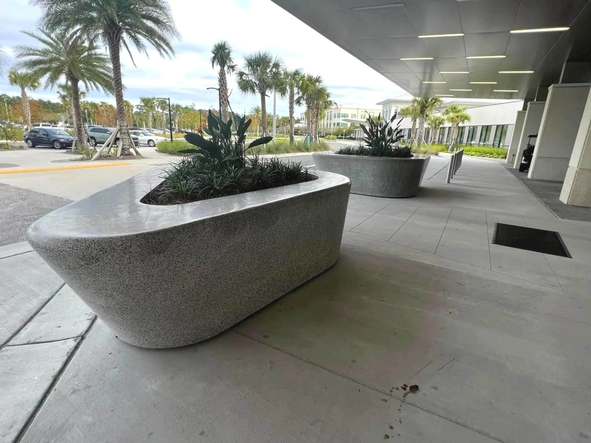 Enormous polished granite agreggate 7000 lb three-sided planters located at the front door of Baptist Medical Center (BMC) Clay in Fleming Island. The planters presented a bigger challenge than is casually obvious. The angles on the vertical faces ch