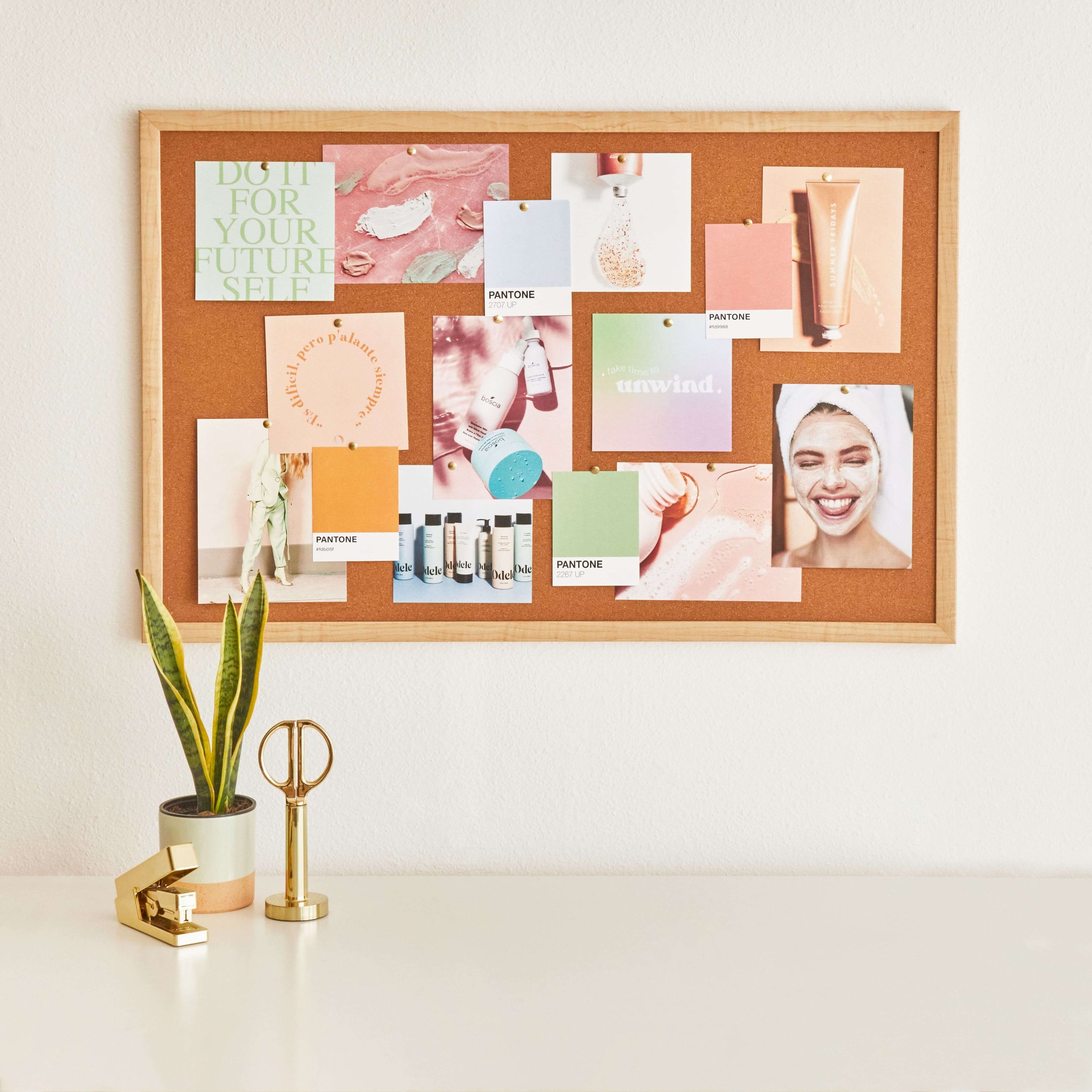 Spring Cleaning Tips to Breathe Life into Your Workspace: A corkboard with various bright images hangs on a white wall.