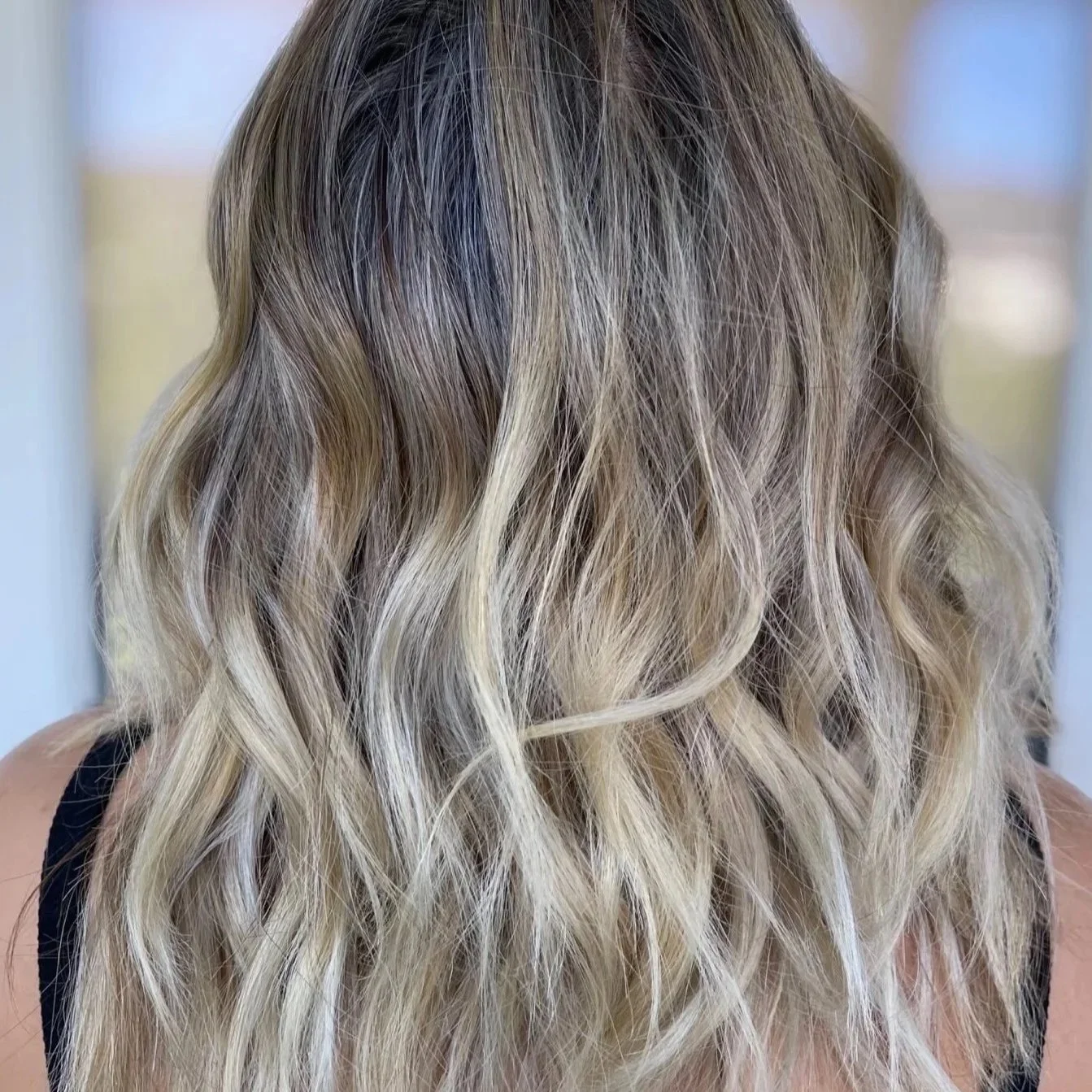 Lived-in blonde highlights with soft waves at Kindred Color Studio in Woodbridge, VA