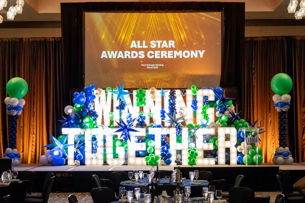 Awards ceremony stage decorated with blue, green and white balloons