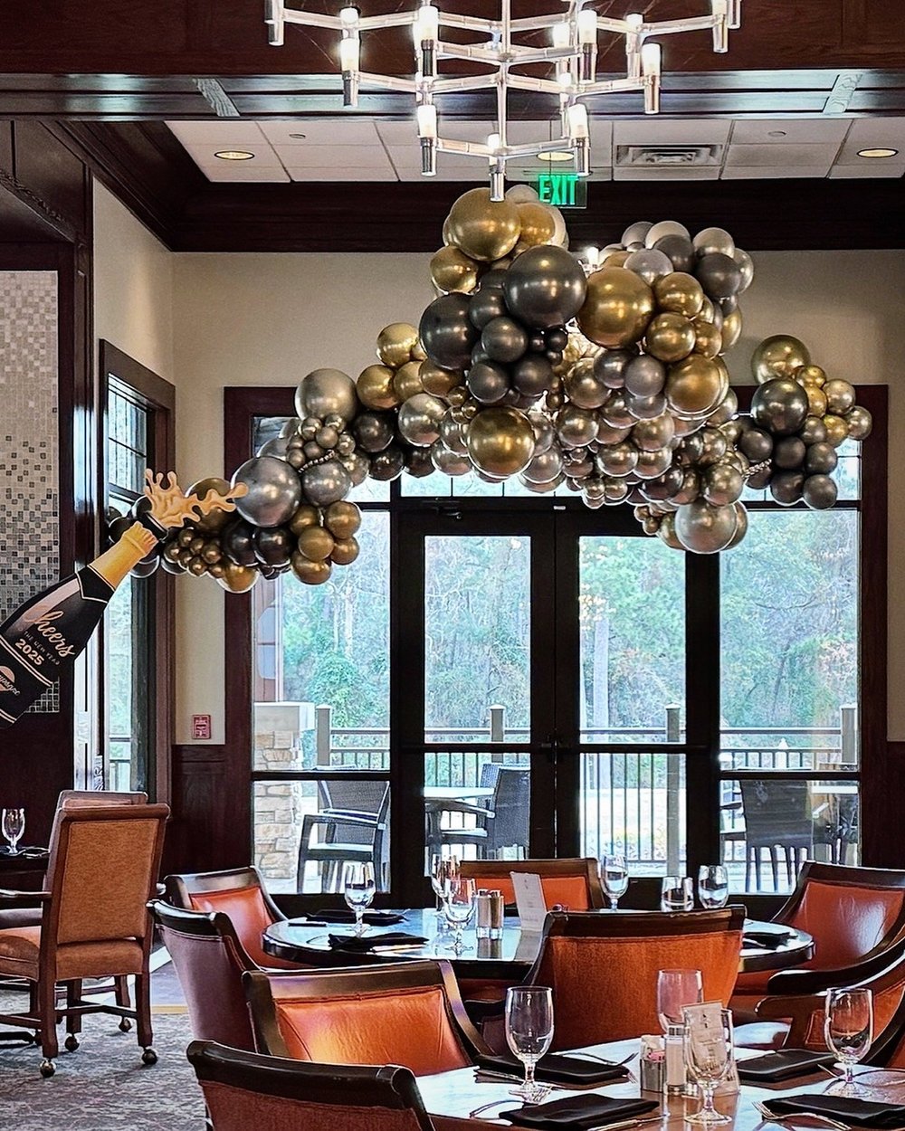 Balloon chandelier in black, gold and silver above a restaurant dining room