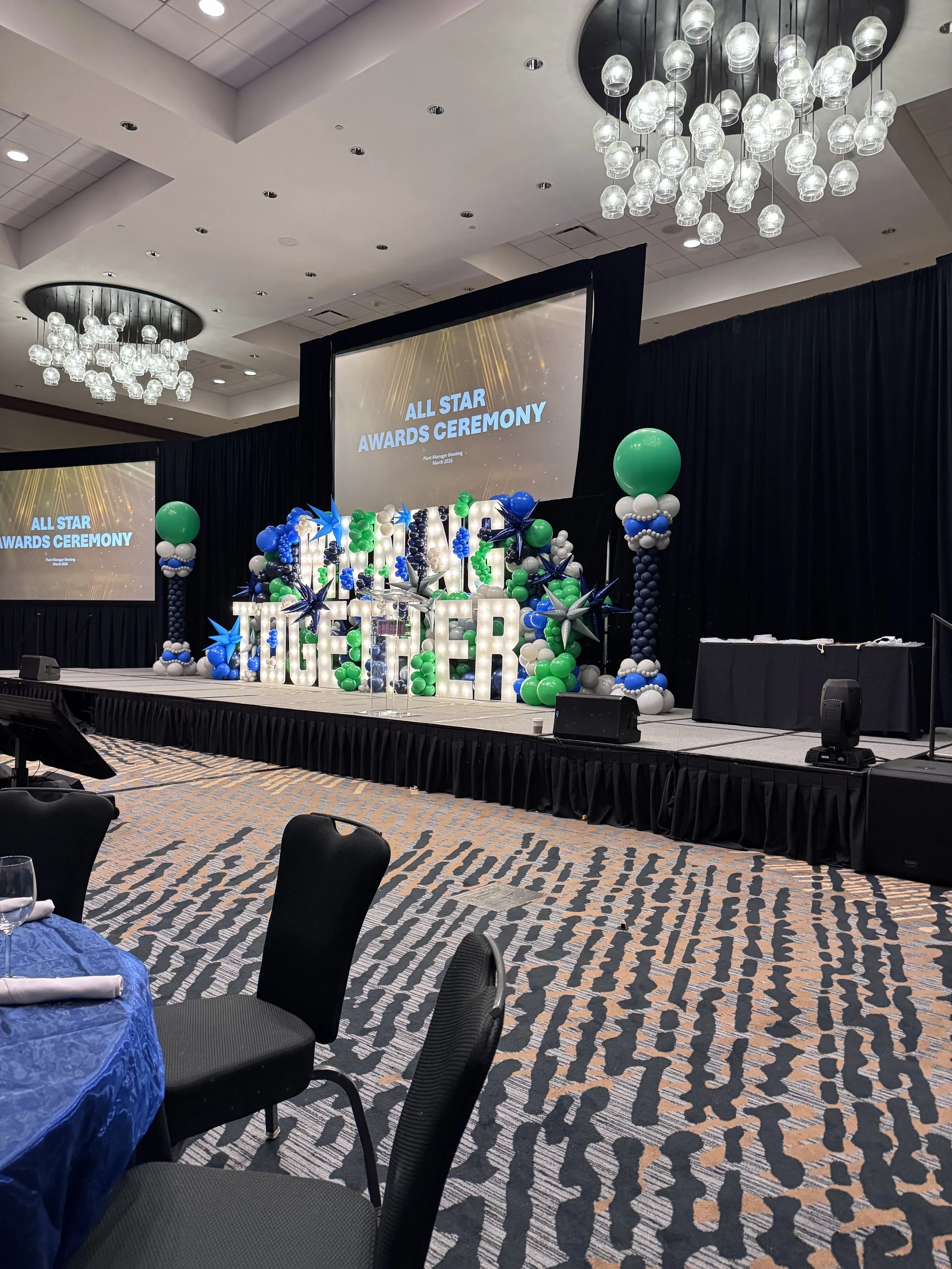 Corporate balloon stage backdrop with organic garland in royal blue, emerald green and white for All Star Awards Ceremony in The Woodlands TX