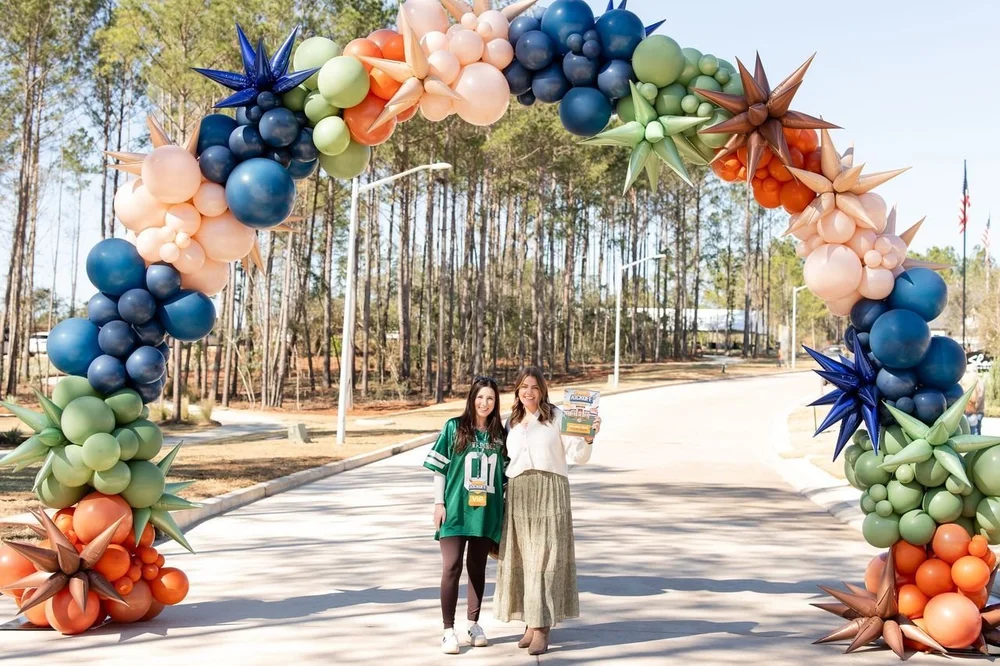 Atirela designers installing a large outdoor balloon arch