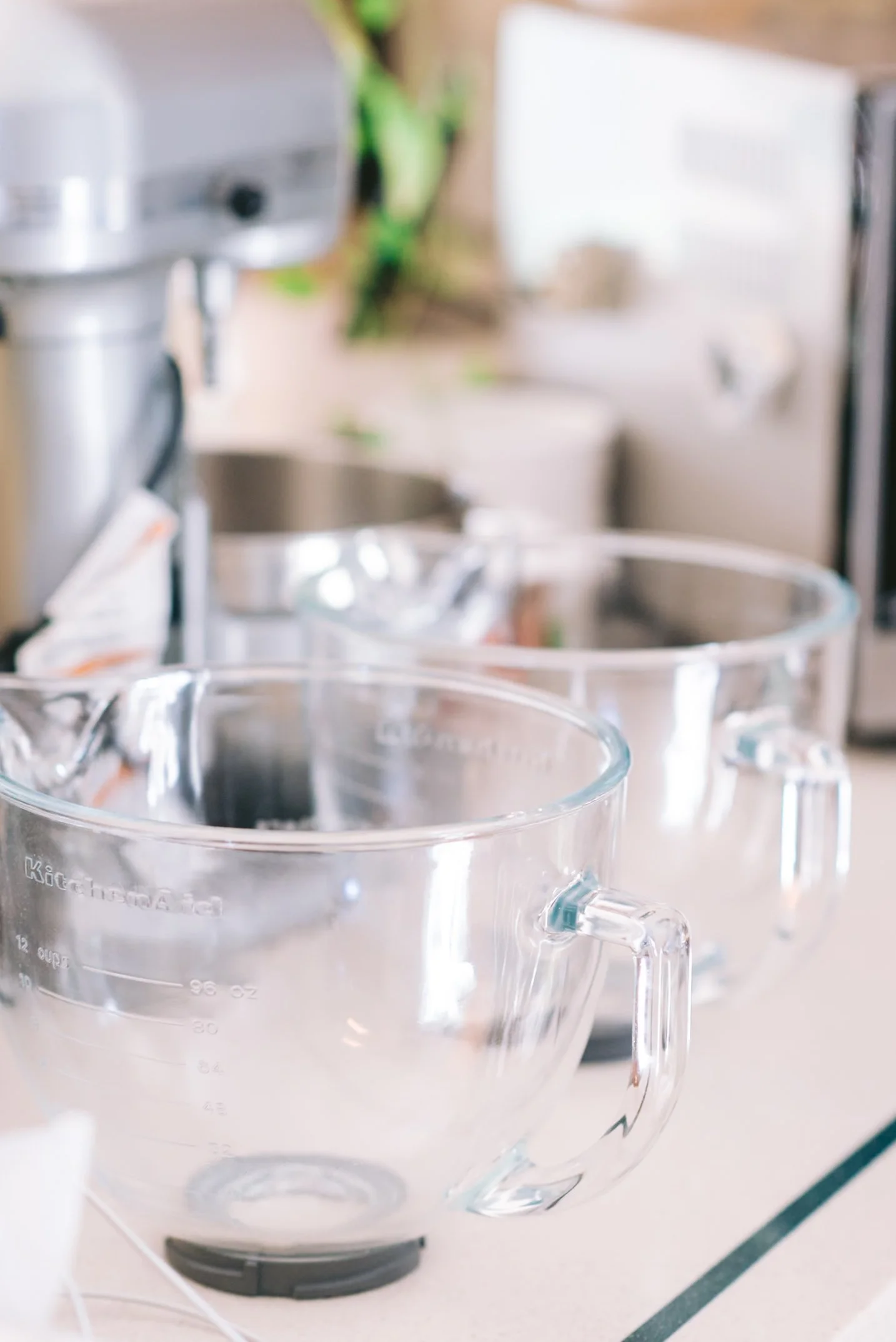 Two clear glass measuring cups on a kitchen countertop.