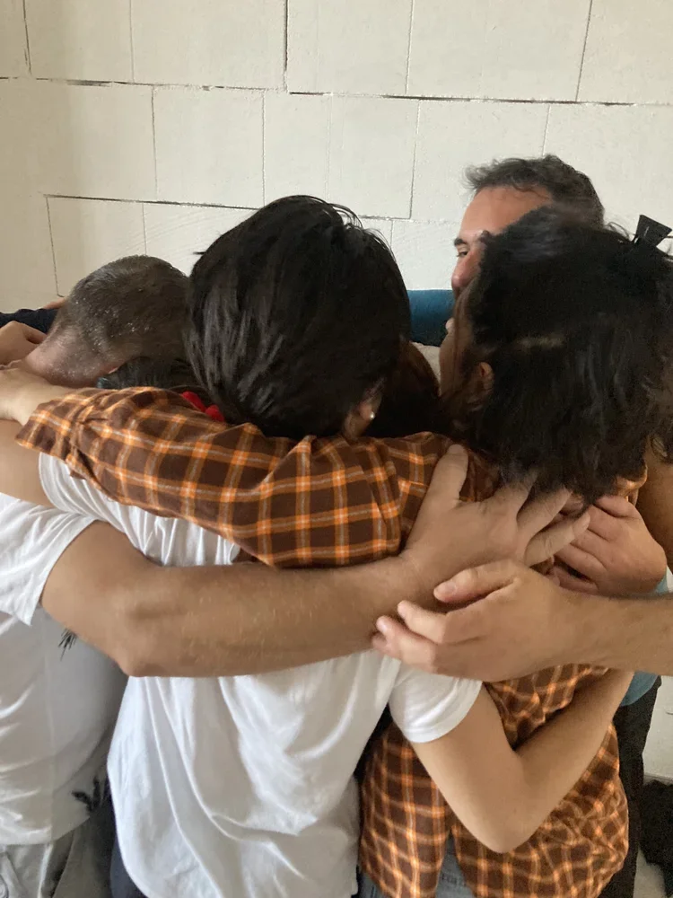 Abbraccio di gruppo durante una giornata di pratica e condivisione
