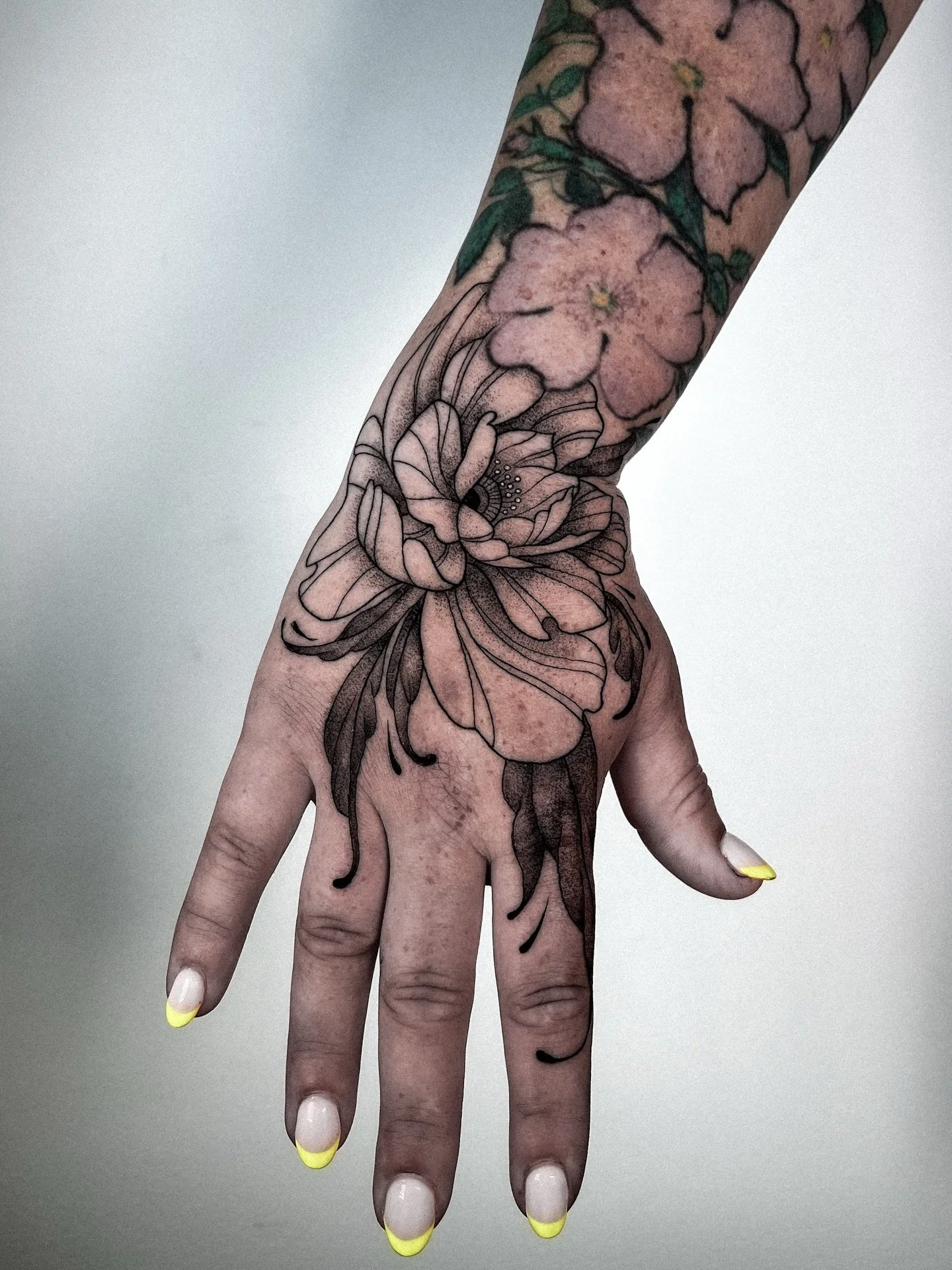 natalie said &ldquo;blast my hand&rdquo; and that is exactly what we did. so appreciative of your trust and vision. 🫶 
she wanted a dark flower on her had with trailing leaves down the fingers 🍃 
.
#handtattoo #seattletattoo #queertattooartist #tra