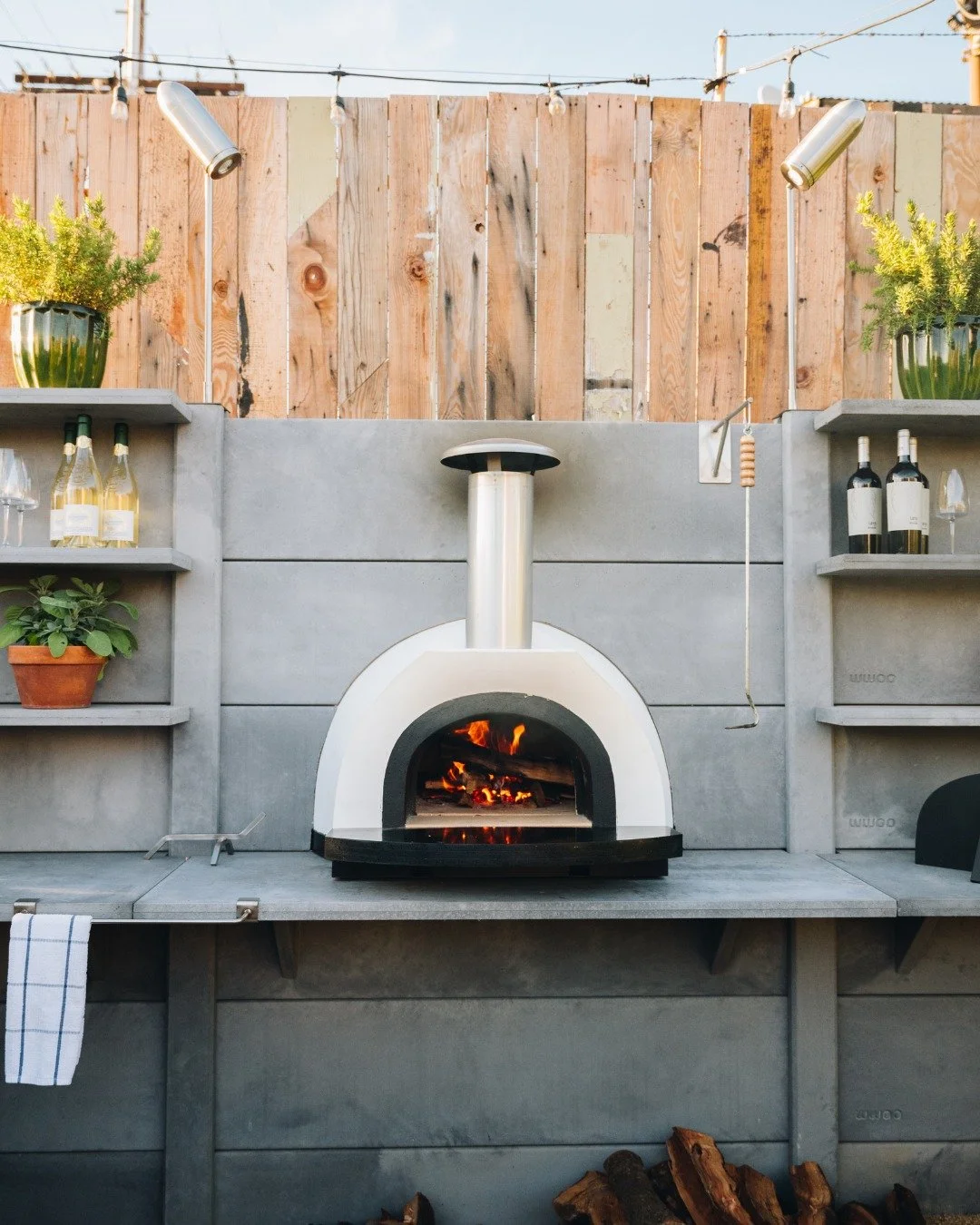 *Name Those Accessories*
In our stunning light gray showroom kitchen we have a @fornopiombo Santino and our WWOO bullet lights.