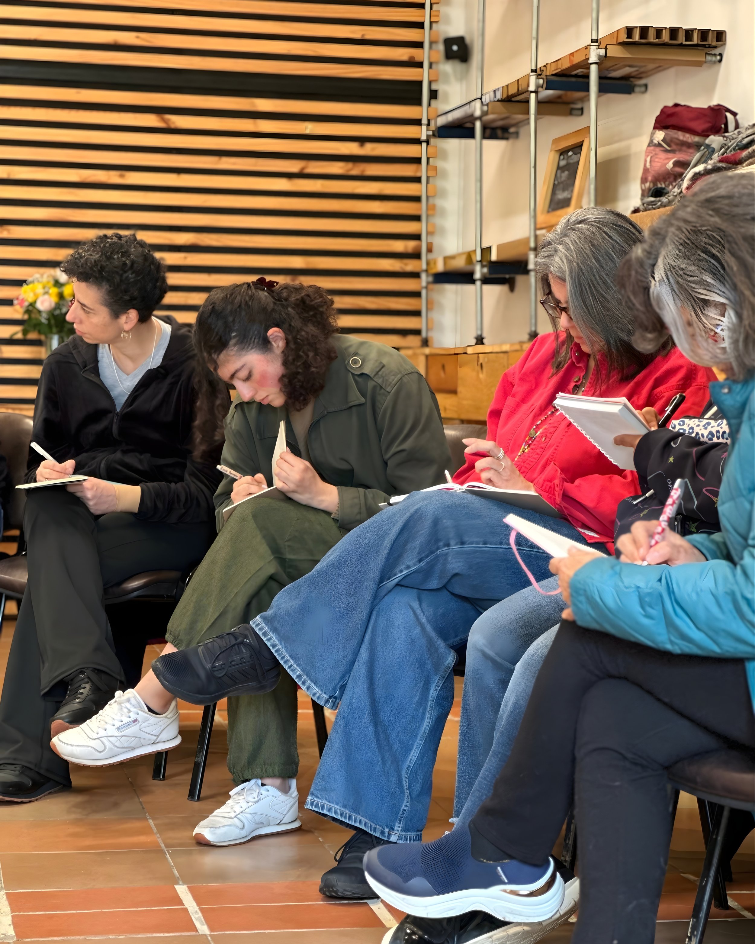 Participantes escribiendo en sus cuadernos durante un ejercicio de reflexión guiada
