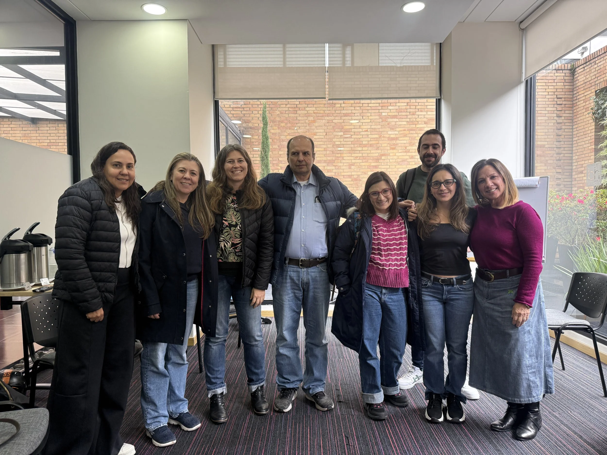 Una mano sostiene una brújula en un entorno natural al atardecer, con agua y cielo en el fondo.