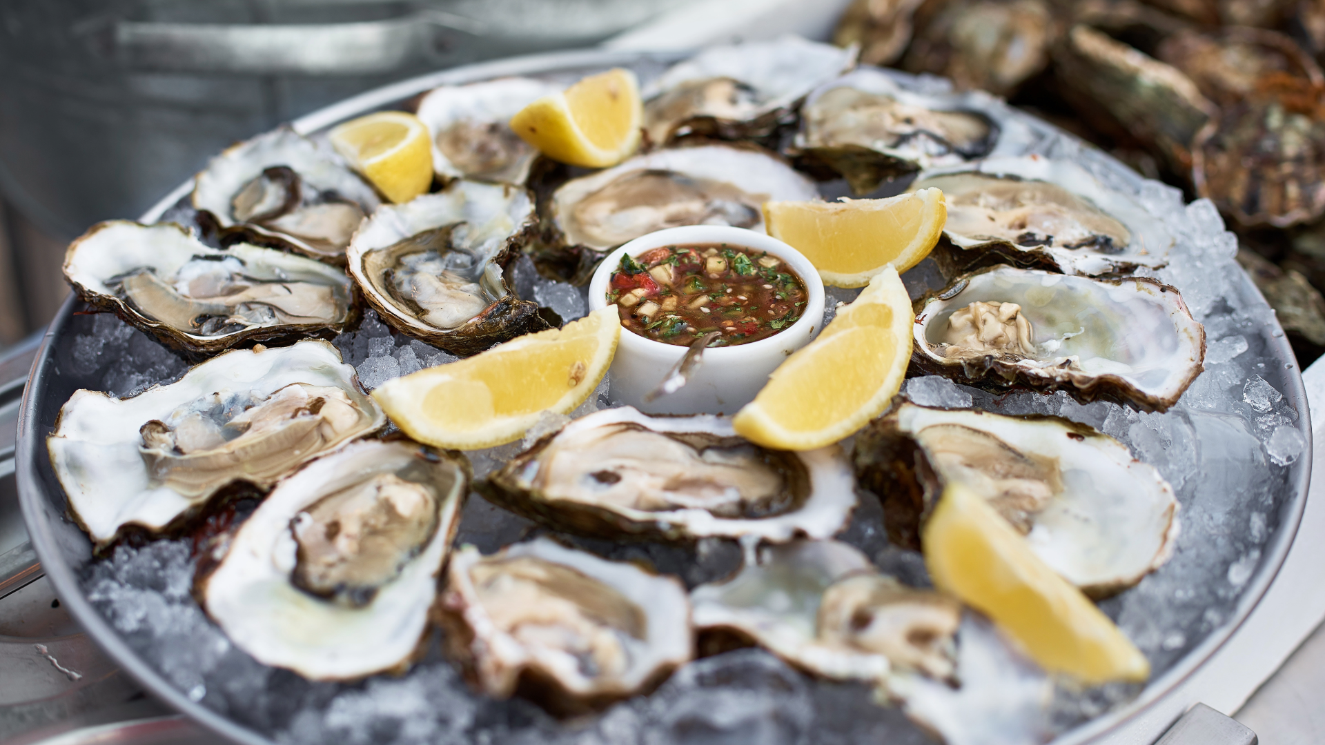 Fresh oysters on the half shell served with lemon wedges and cocktail sauce at a coastal restaurant near Oak Island, North Carolina.
