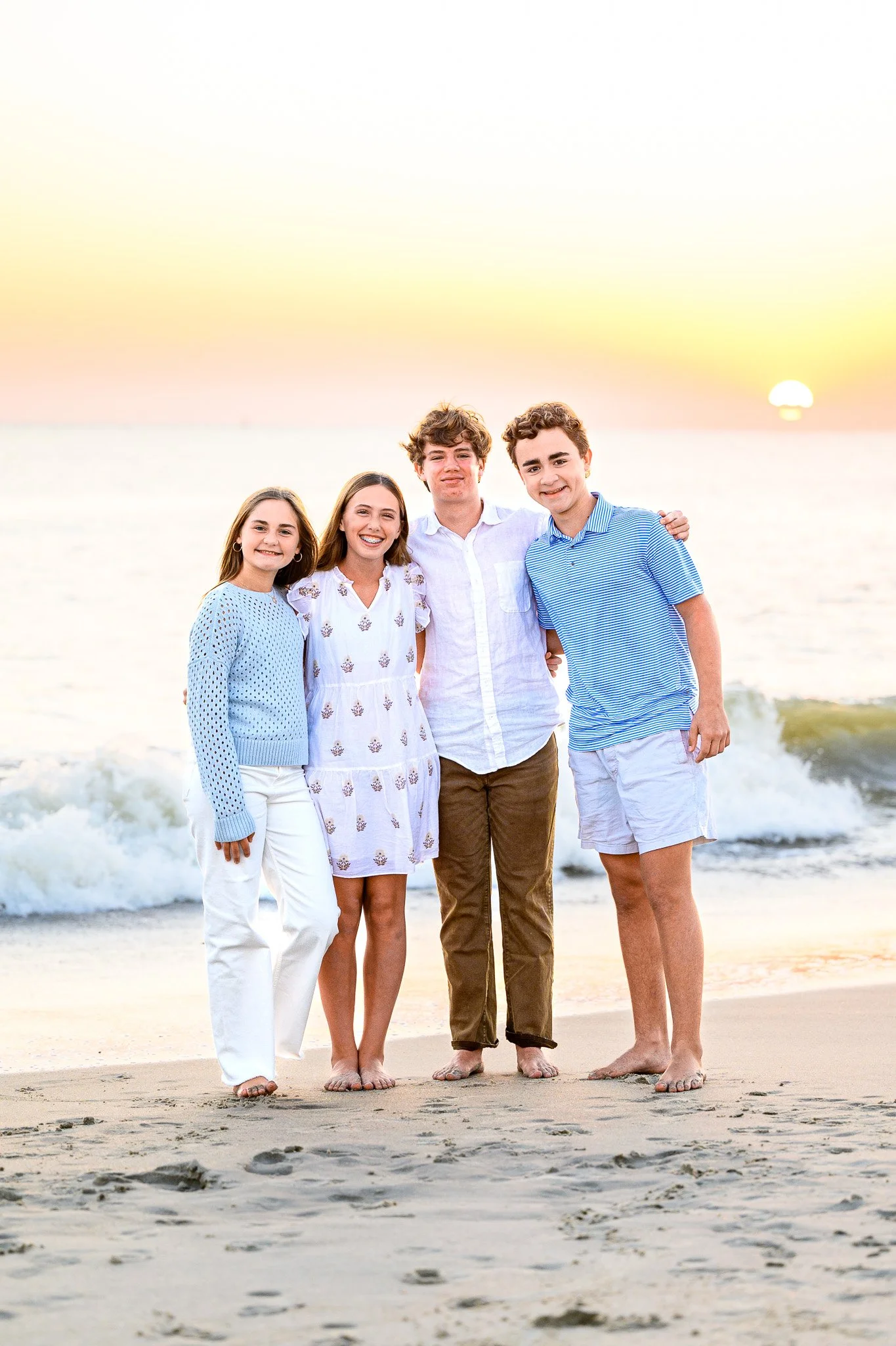 Family posing for sunset beach photos on Oak Island, North Carolina.