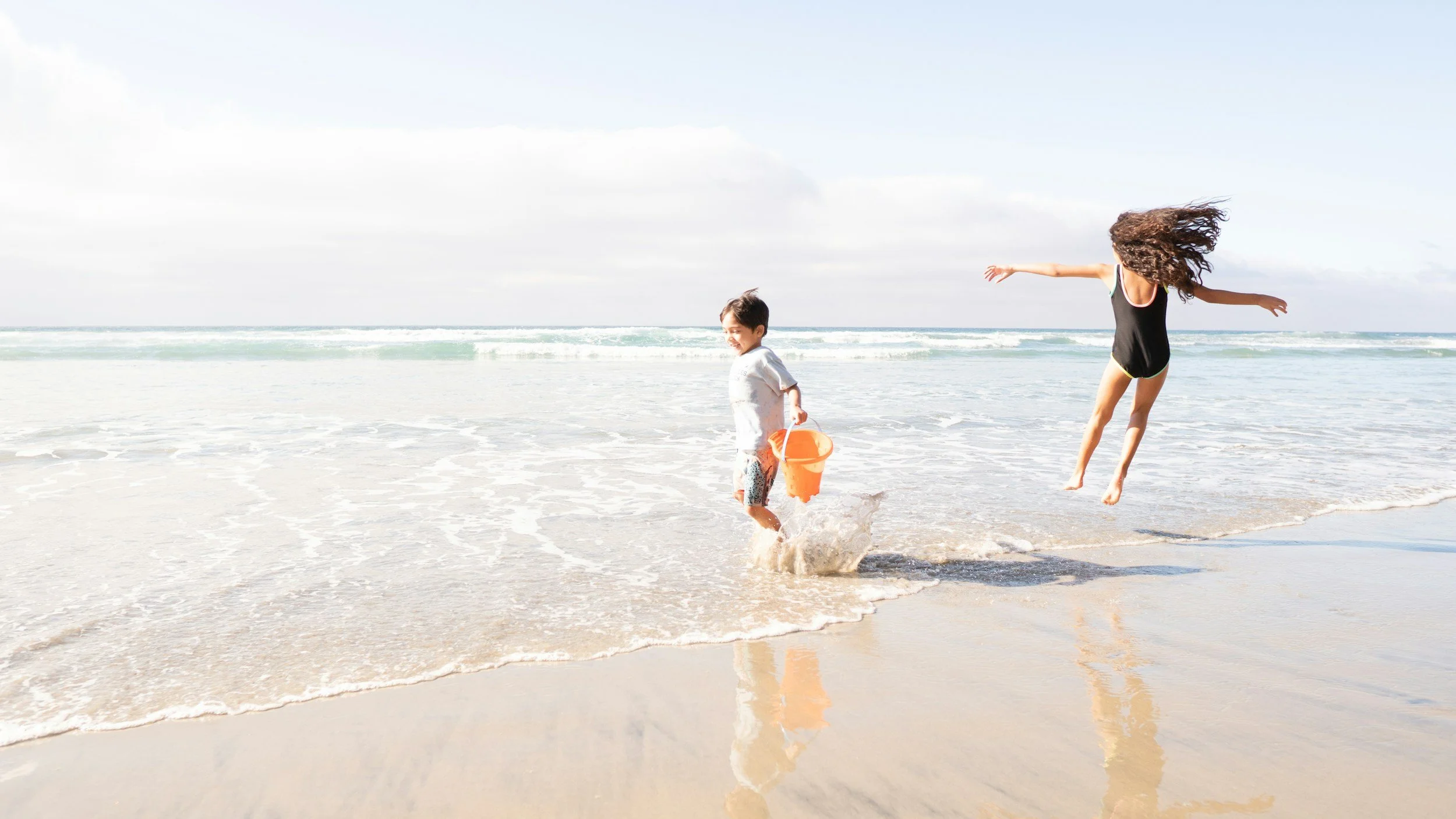 Children playing in the surf and exploring the shoreline on Oak Island, North Carolina.