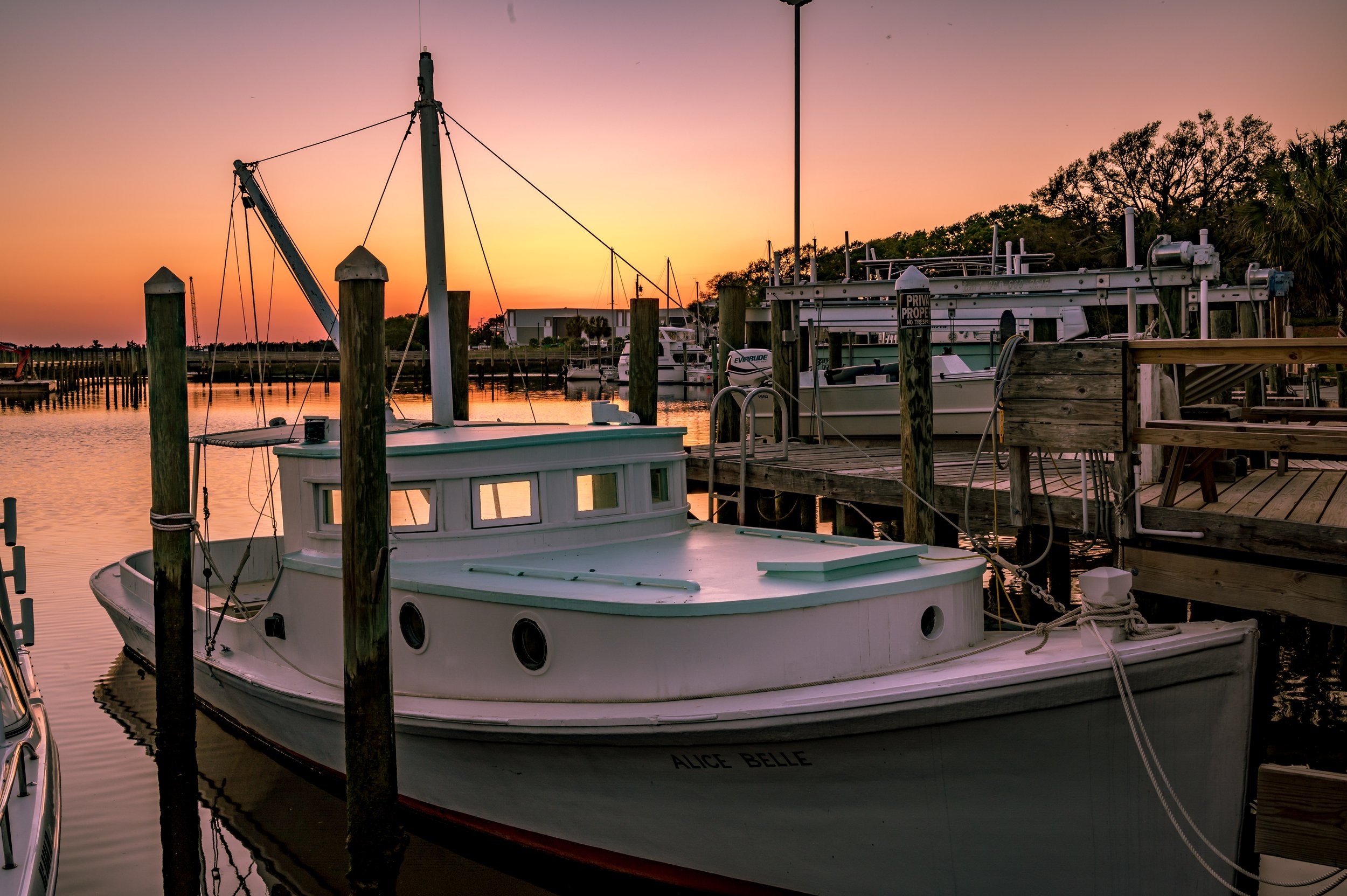 Fishing boat docked along the Southport Yacht Basin waterfront at sunset in Southport, North Carolina.