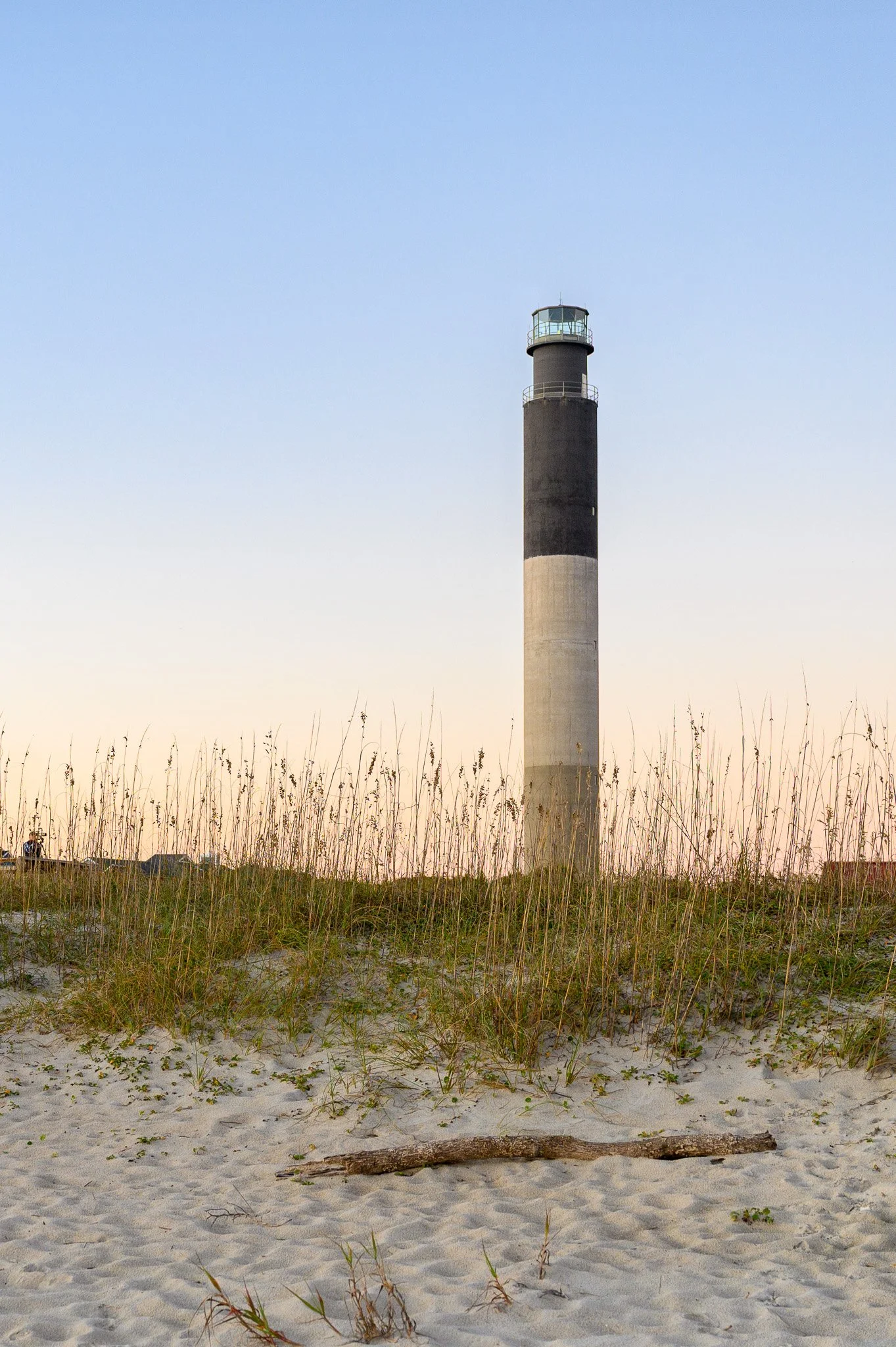 The Oak Island Lighthouse rises above sea oats and sand dunes at Caswell Beach on Oak Island, North Carolina.