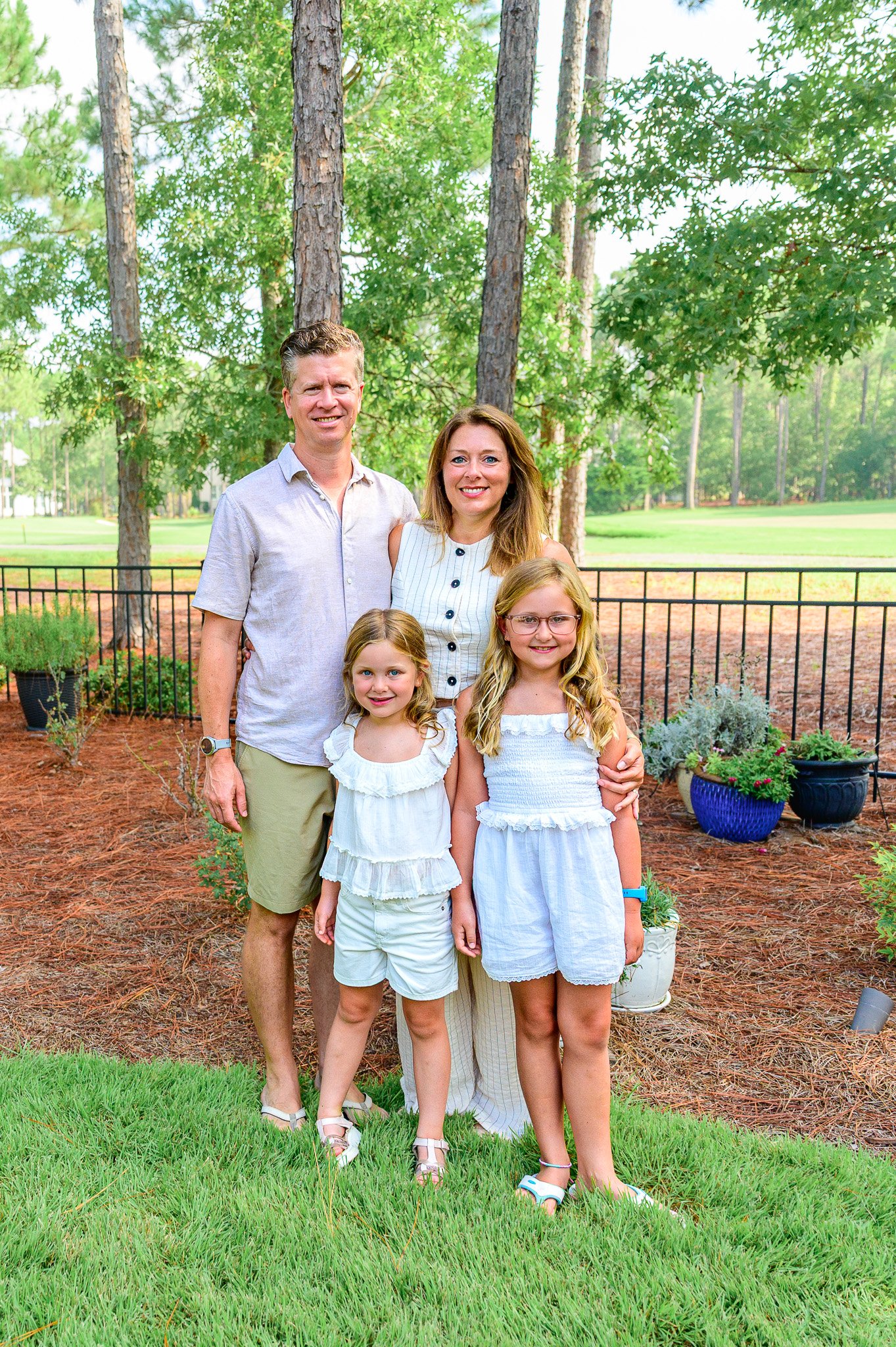 A family of four posing for family photos in Southport, NC