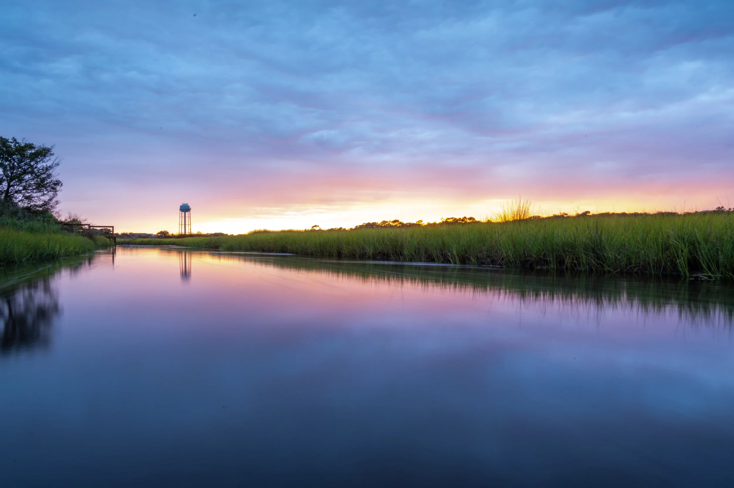 Sunset reflecting across the marsh and waterways of Oak Island, North Carolina.