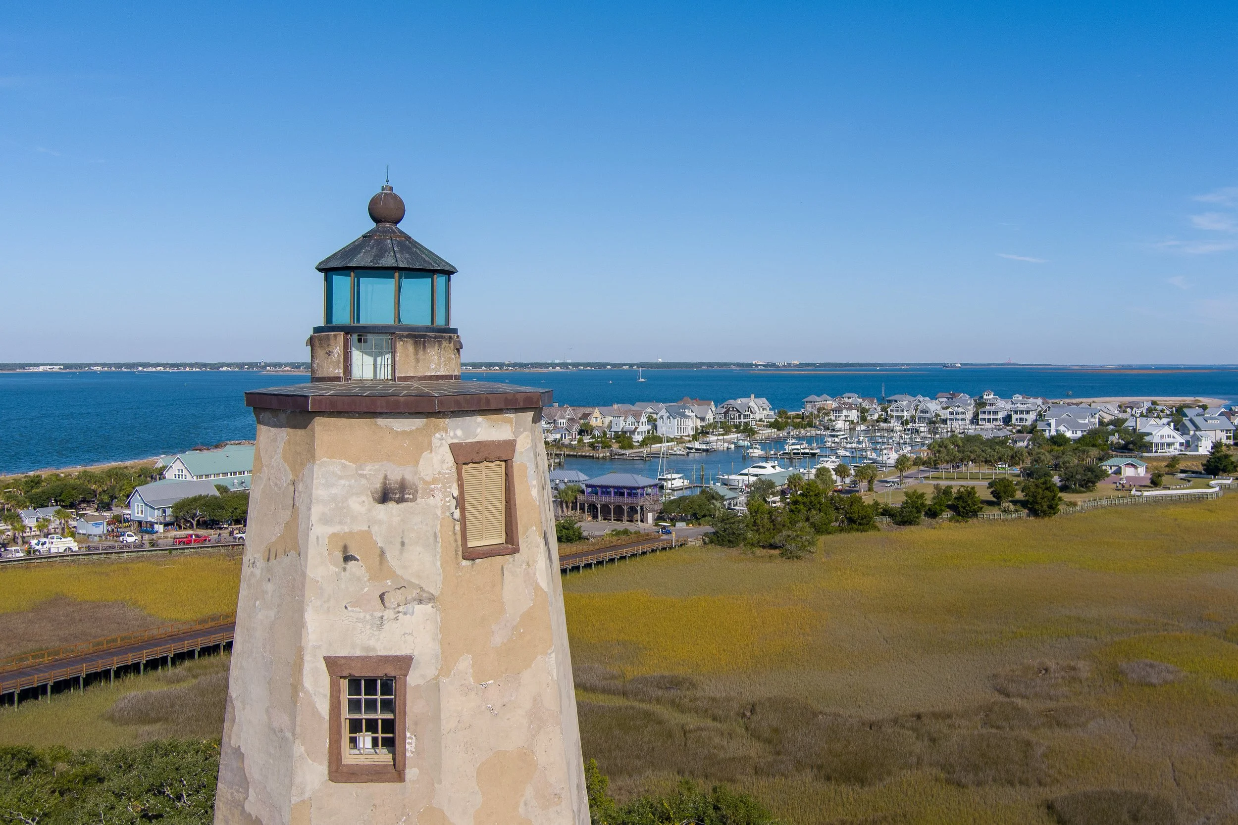 Old Baldy Lighthouse overlooking Bald Head Island Marina, harbor, and village waterfront on Bald Head Island, North Carolina.