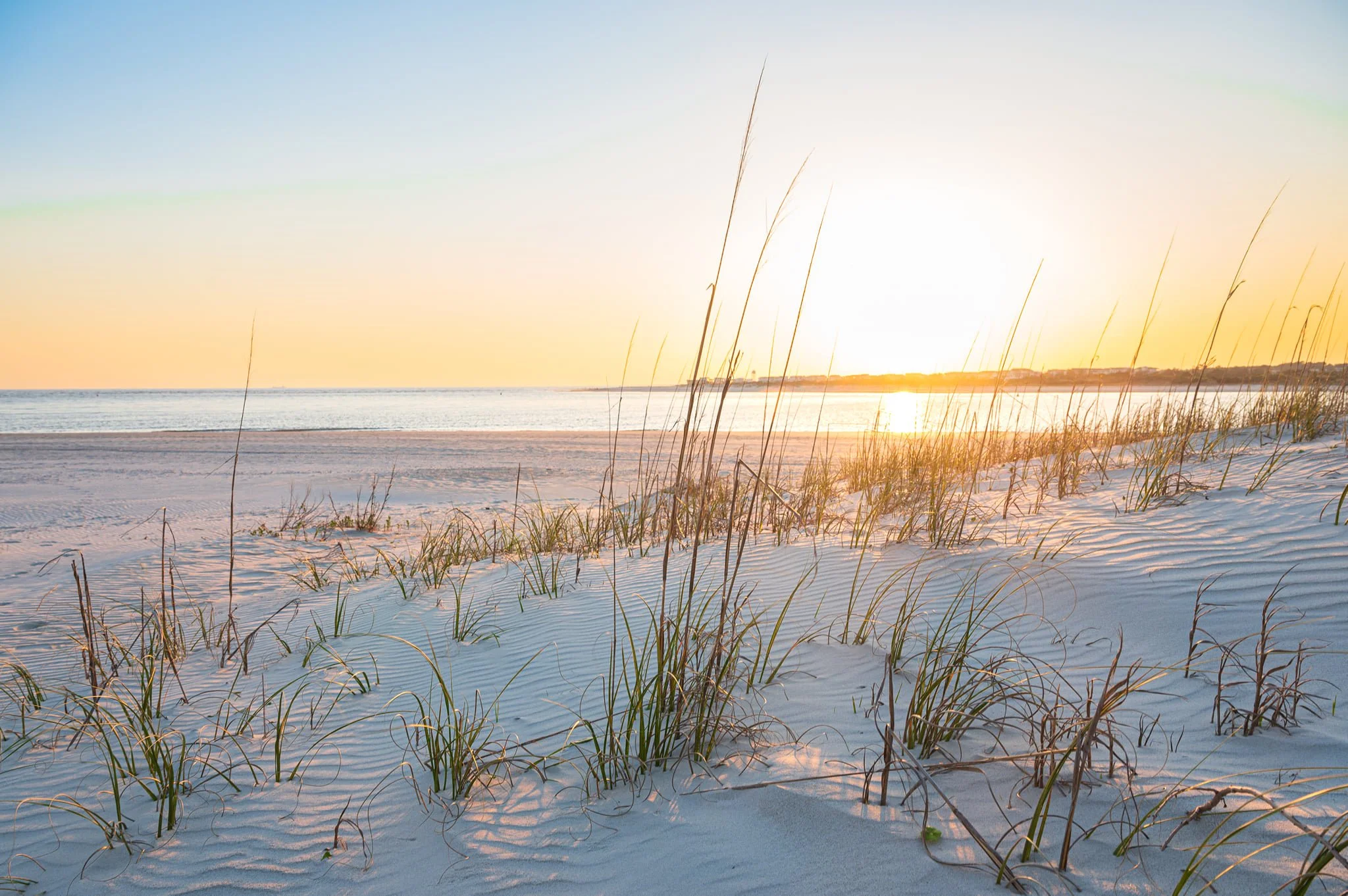 Sunset over the beach and sea oats at The Point on Oak Island, North Carolina.