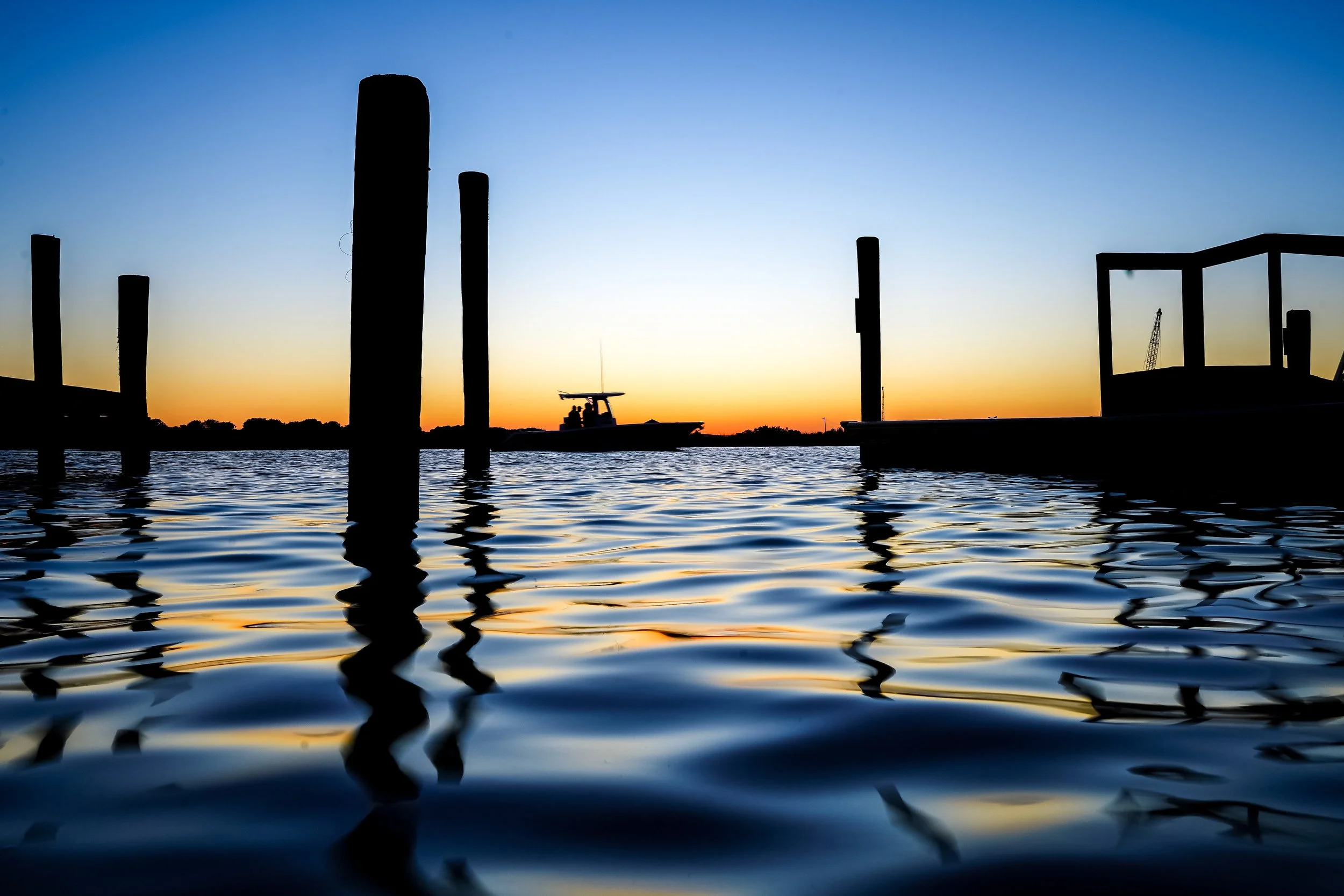 Boat cruising through the Intracoastal Waterway at sunset near Oak Island, North Carolina.