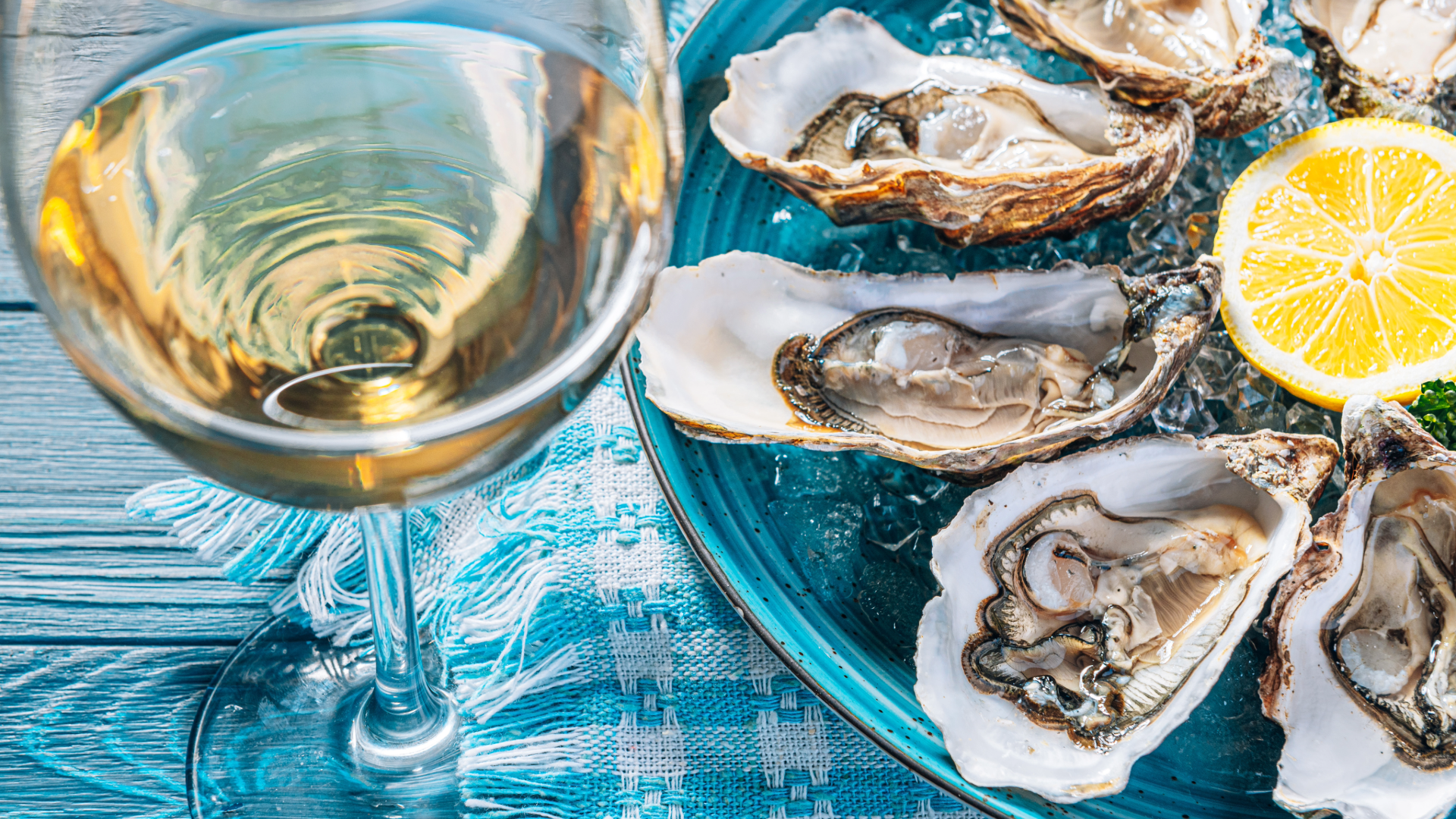 Fresh oysters served with lemon and a glass of white wine at a coastal restaurant near Oak Island, North Carolina.