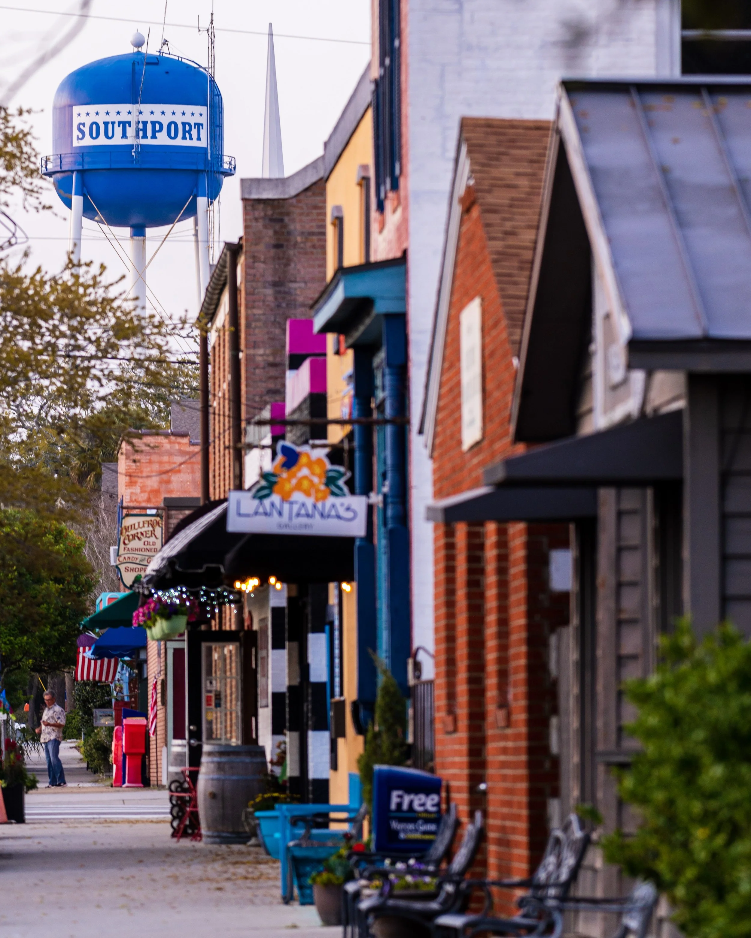 Historic storefronts and the iconic Southport water tower in downtown Southport, North Carolina.