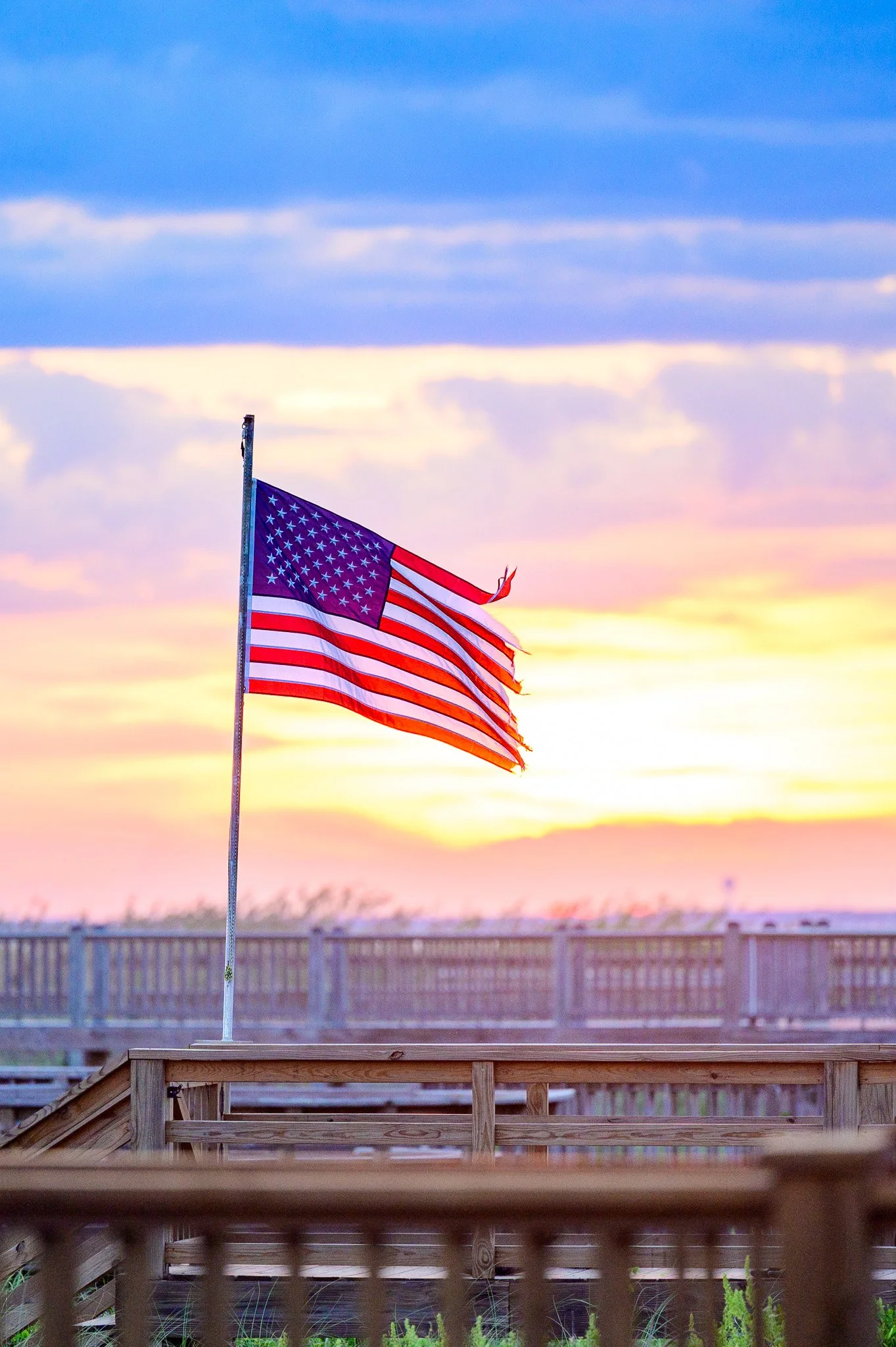 American flag flying at sunset near Caswell Beach on Oak Island, North Carolina.