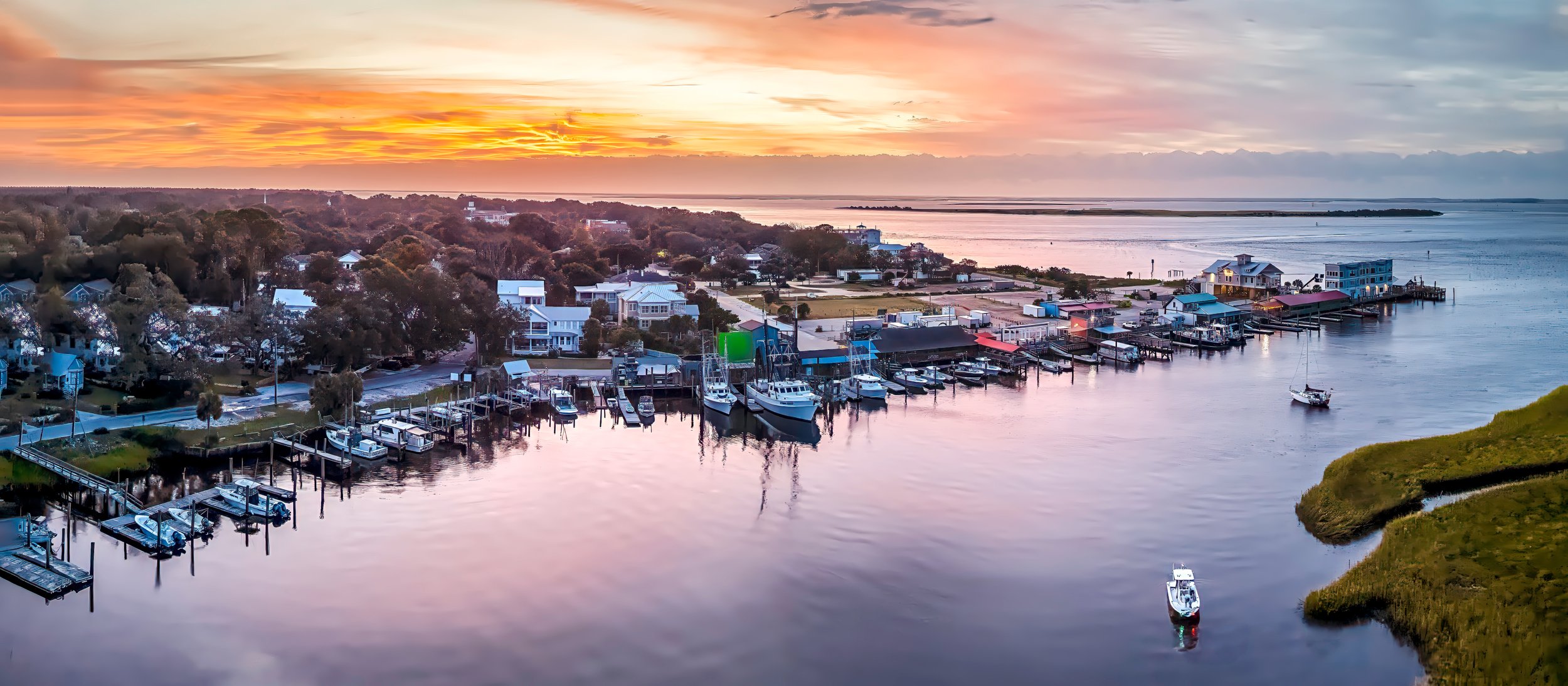 Aerial view of Southport's waterfront marina and yacht basin at sunrise in Southport, North Carolina.
