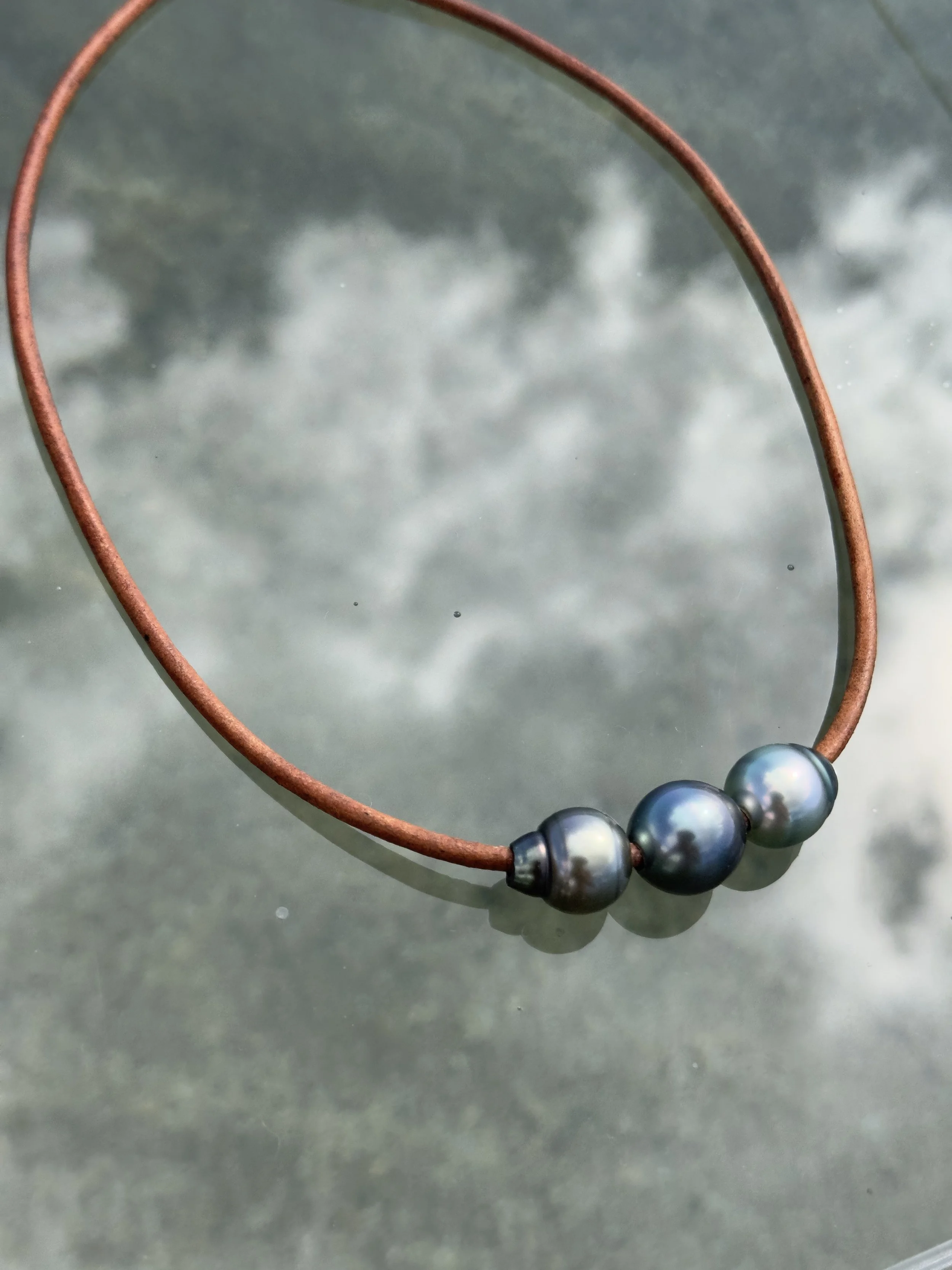 Handcrafted Leather + Bombucha Tahitian Pearl Necklace from Maui, featuring three large luminous pearls on natural leather