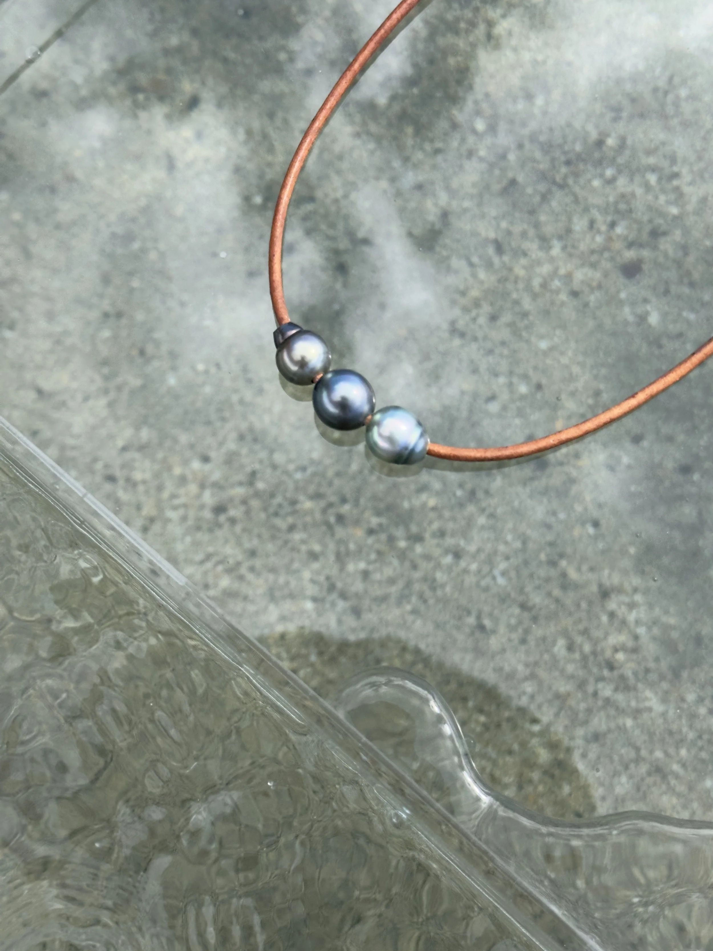 Elegant leather and pearl necklace from Maui, featuring three large luminous Bombucha Tahitian pearls—handmade and unique
