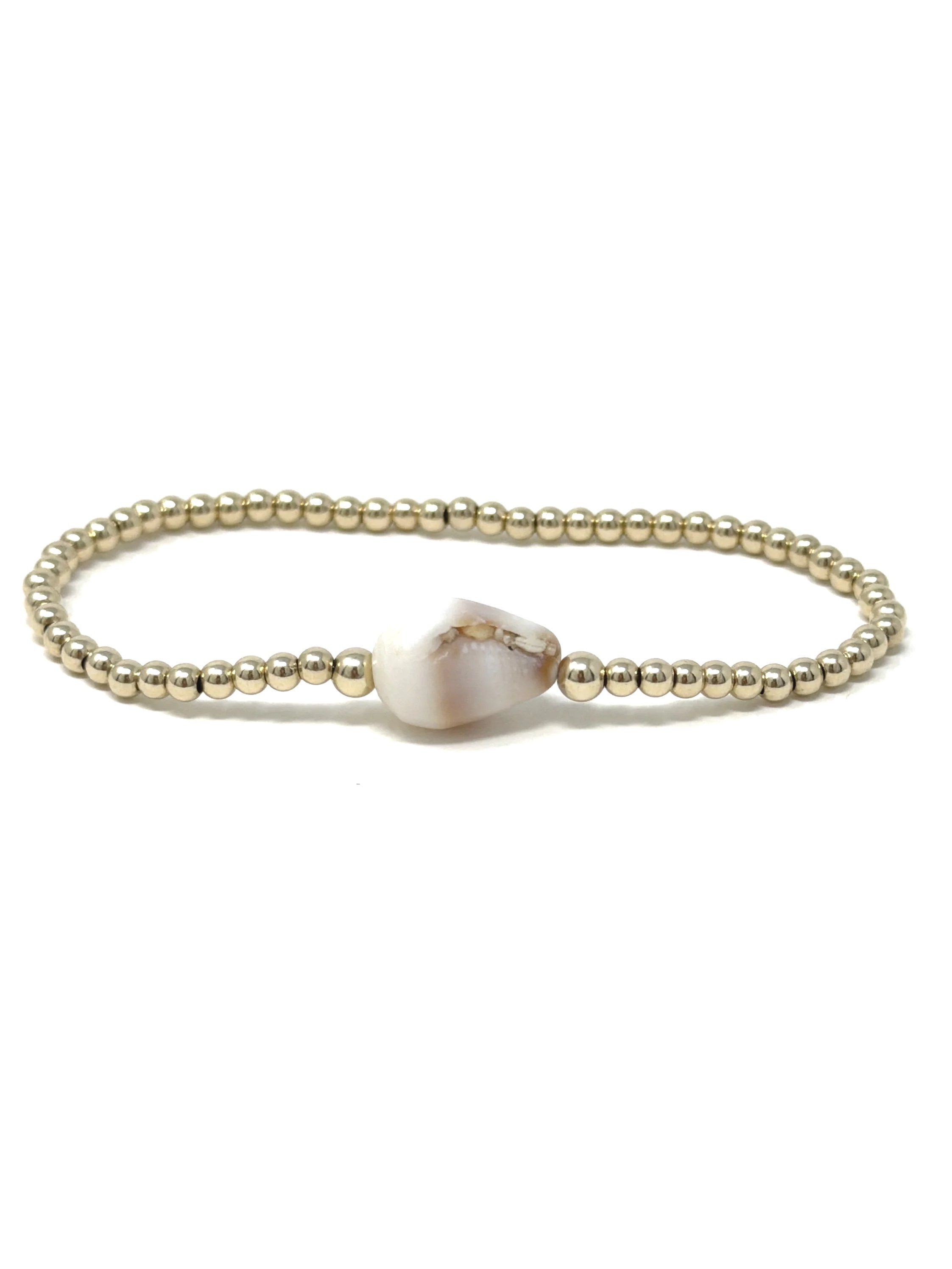 Ocean-inspired cone shell bracelet with natural shell centerpiece and delicate metal beads. Lightweight, stretchy, and perfect for everyday coastal style.