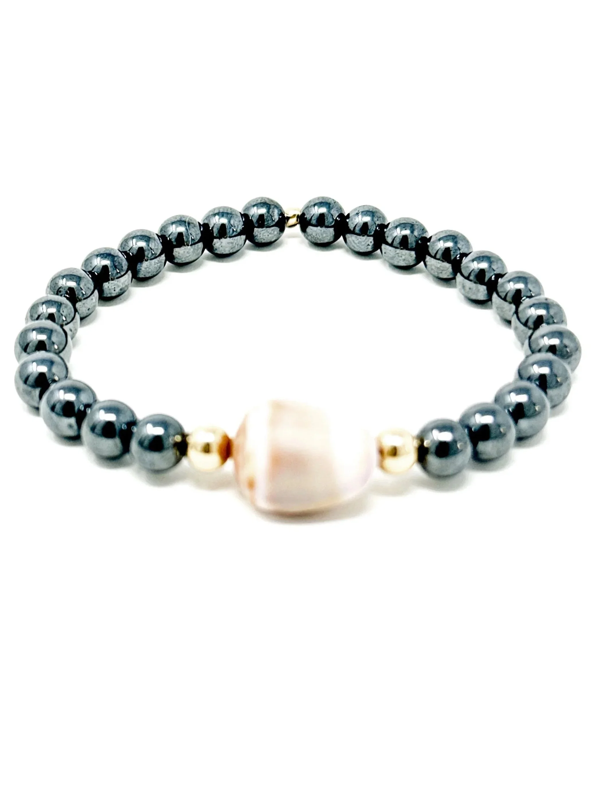 Handmade bracelet featuring a real cone shell found on Maui paired with dark hematite beads. Stretchy, lightweight, and perfect for everyday wear or layering.