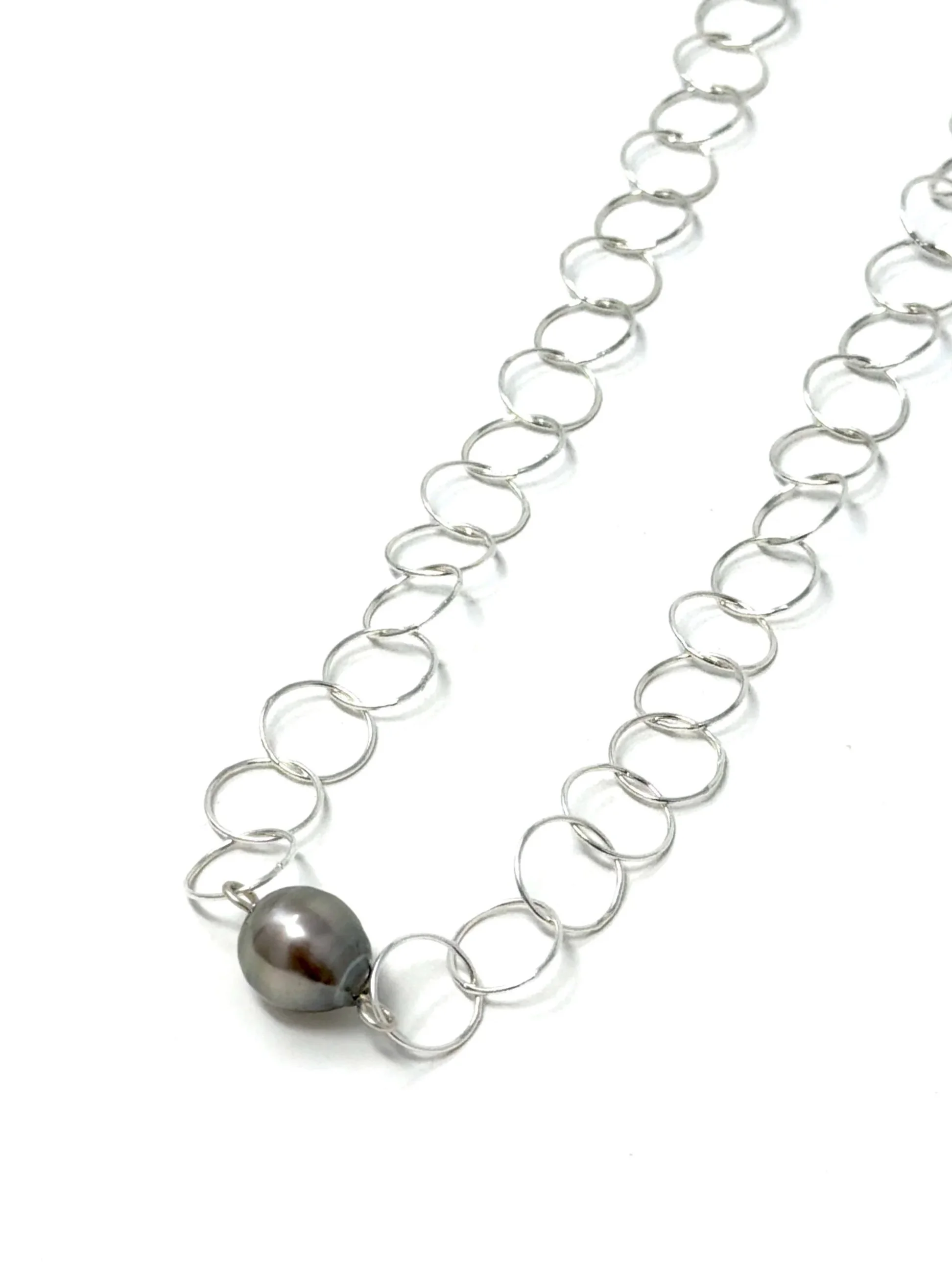 Minimalist pearl necklace with interlocking circles and a hand-selected pearl centerpiece. Adjustable, stackable, and lightweight.