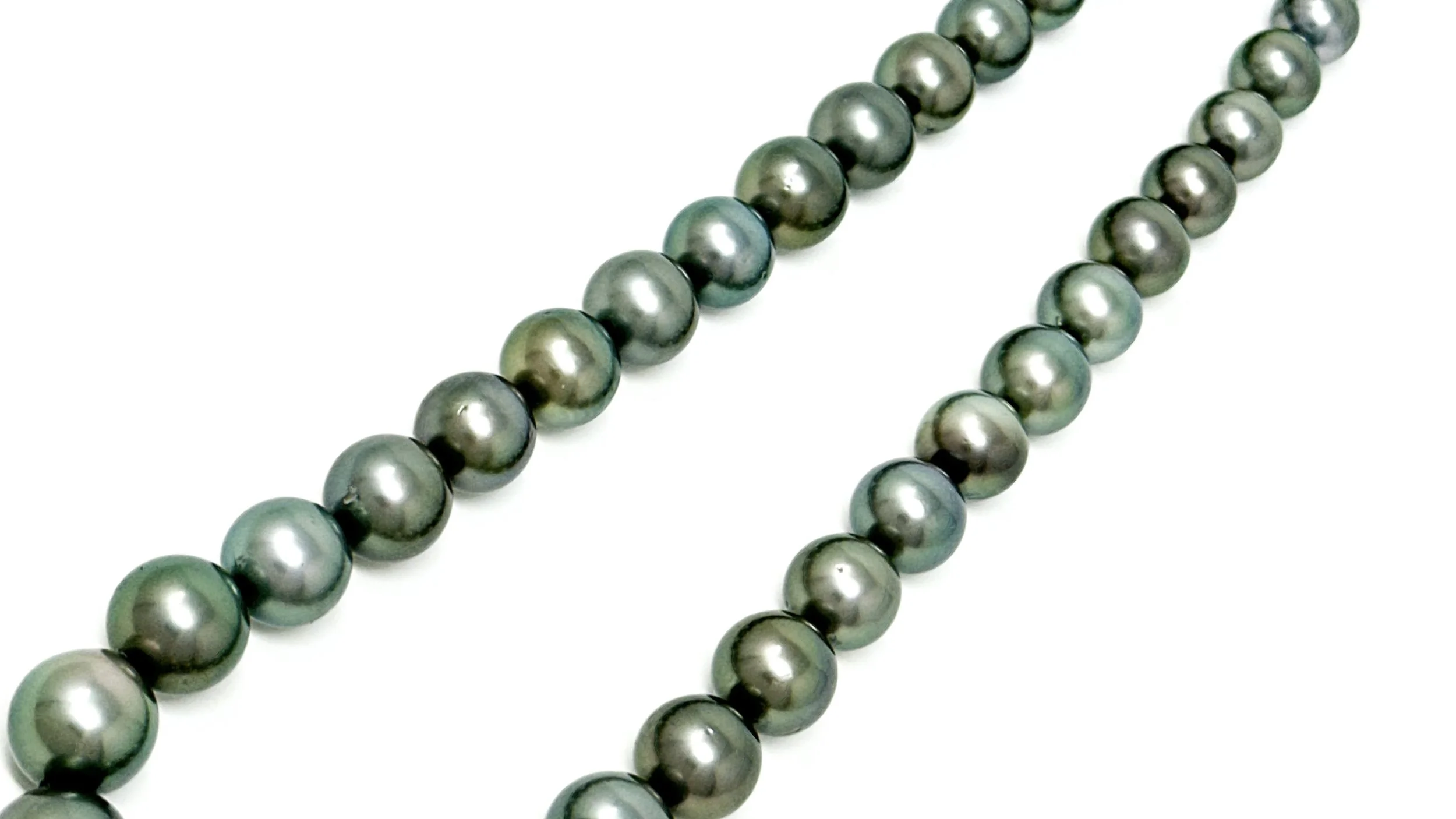Close-up of Tahitian near-round pearls showing silvery luster and natural variation in surface