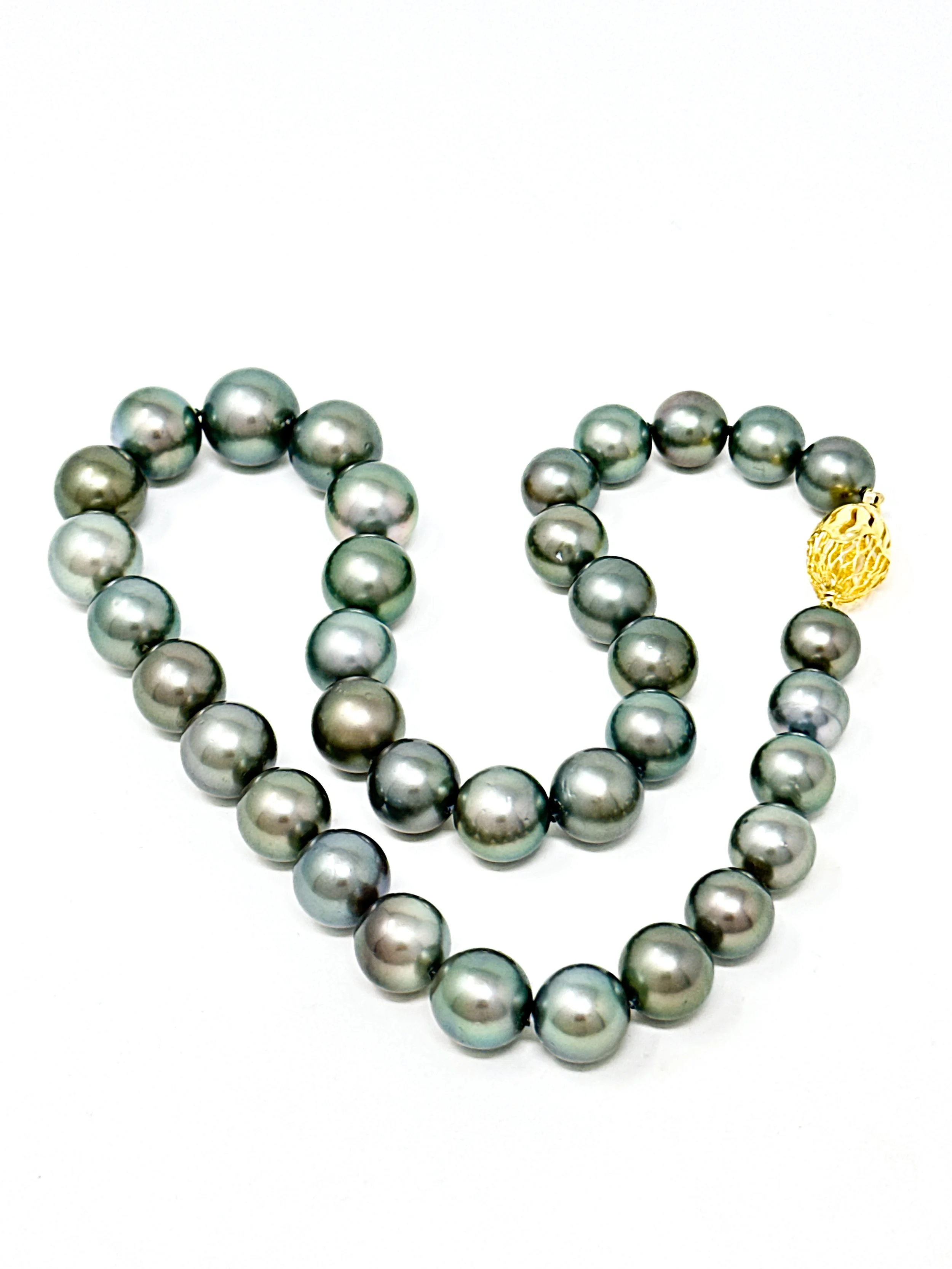 Luminous Tahitian pearl strand necklace in soft natural light highlighting ocean-inspired tones