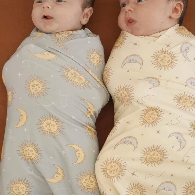 Celestial_sun_moon_baby_bamboo_swaddle_cream_blue.webp